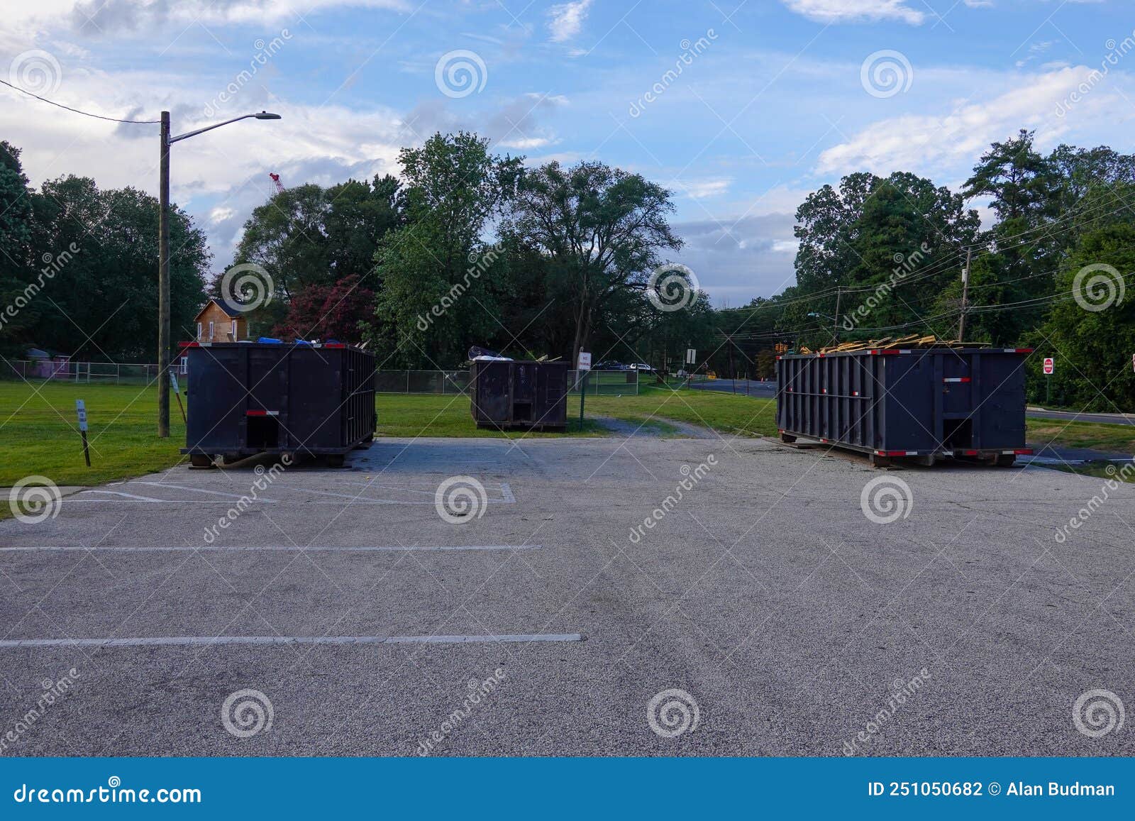 A Group of Three Long Blue Dumpsters Full of Construction Debris in a