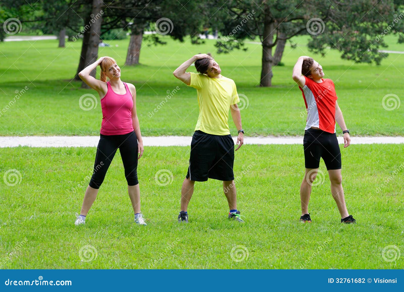 Group of Three Young Athletes Doing Stretching Exercise Stock Photo