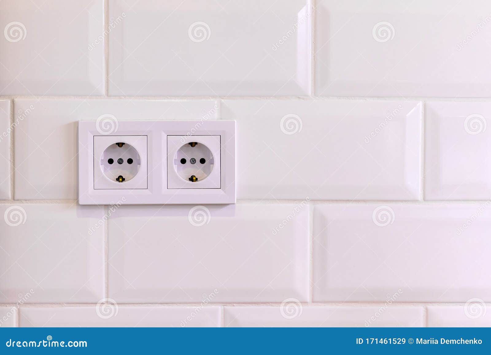 Group of Two White European Electrical Outlets on a Wall of White Tile