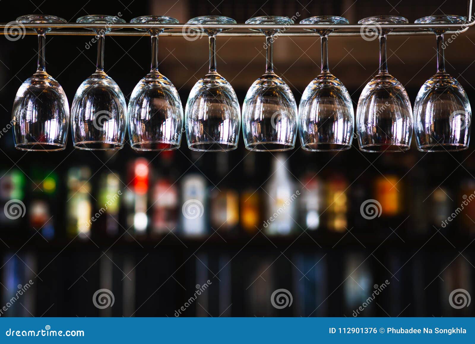 group of wine glasses hanging above a bar rack in pub & restaurant