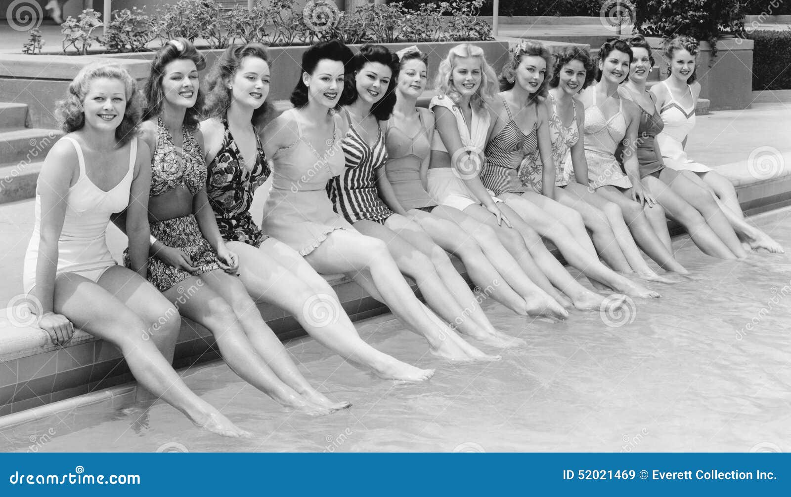 group of women sitting in a row at the pool side
