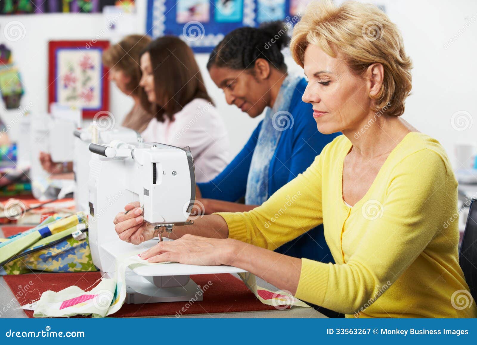 Group of Women Using Electric Sewing Machines in Class Stock Image
