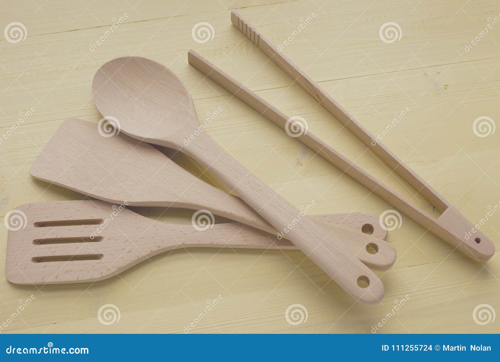A Selection of Wooden Kitchen Utensils on Yellow Work Surface Stock