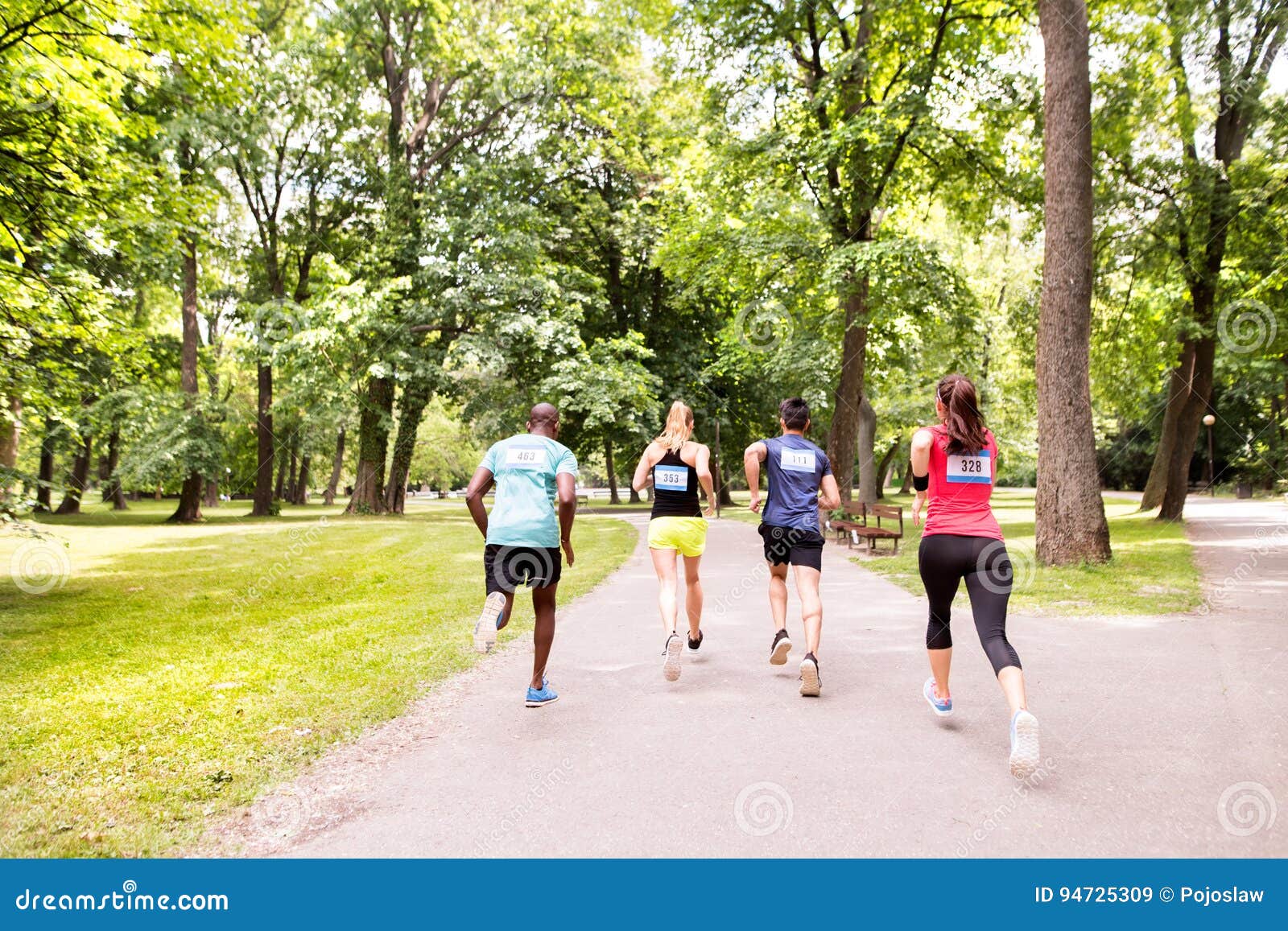 Group of Young Athletes Running in Green Sunny Park. Stock Image