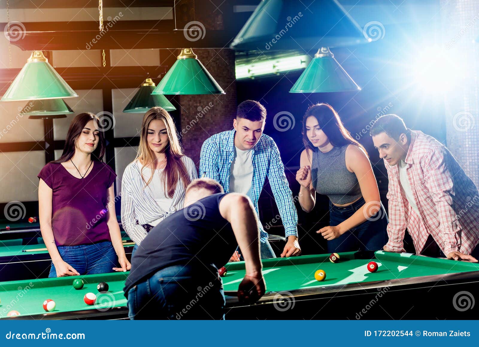 Group of Young Cheerful Friends Playing Billiards. Stock Photo Image