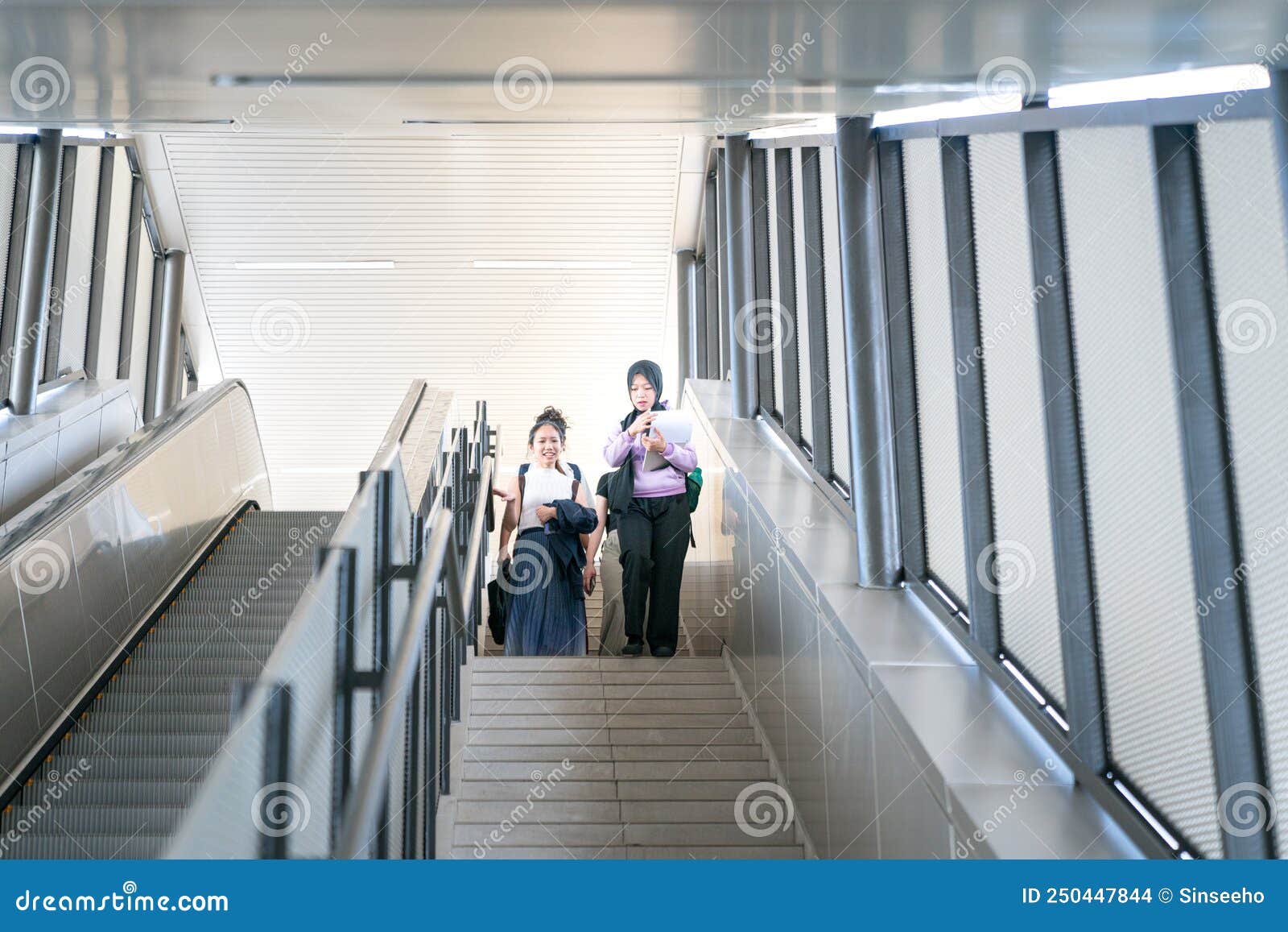 Group of Young Female Students Laughing while Going Down the Stairs