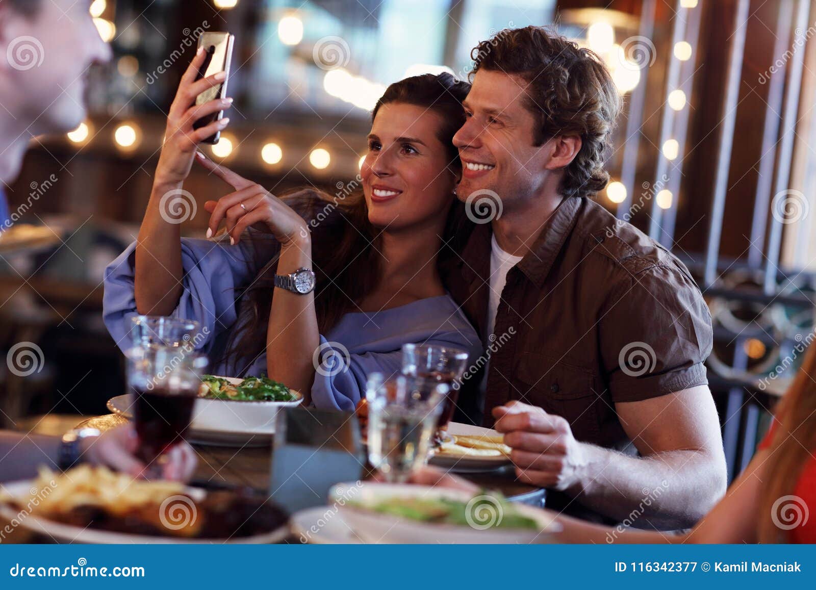 Group Of Friends Enjoying Meal In Restaurant Stock Image - Image of