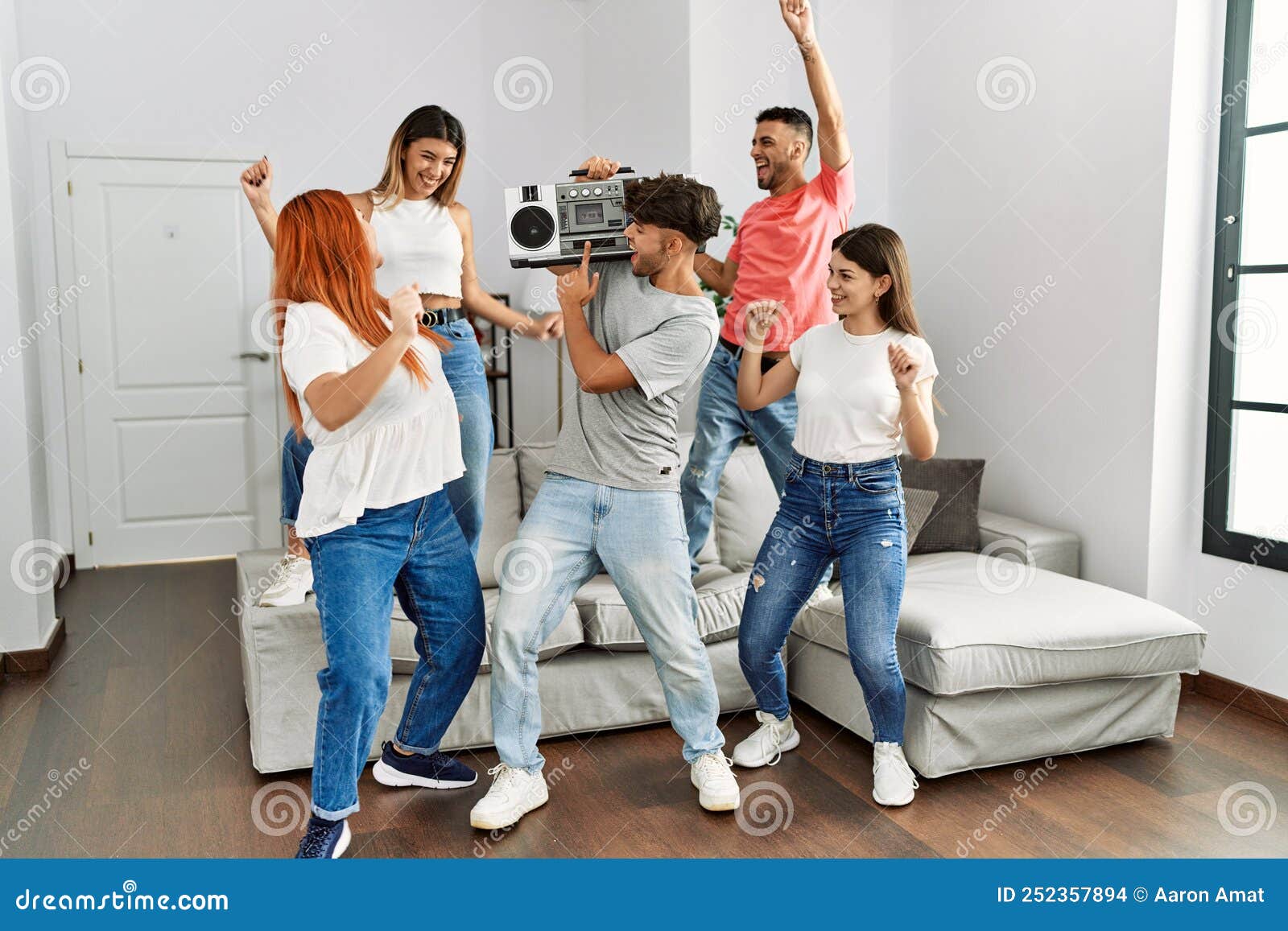 Group of Young Friends Smiling Happy and Dancing at Home Stock Photo