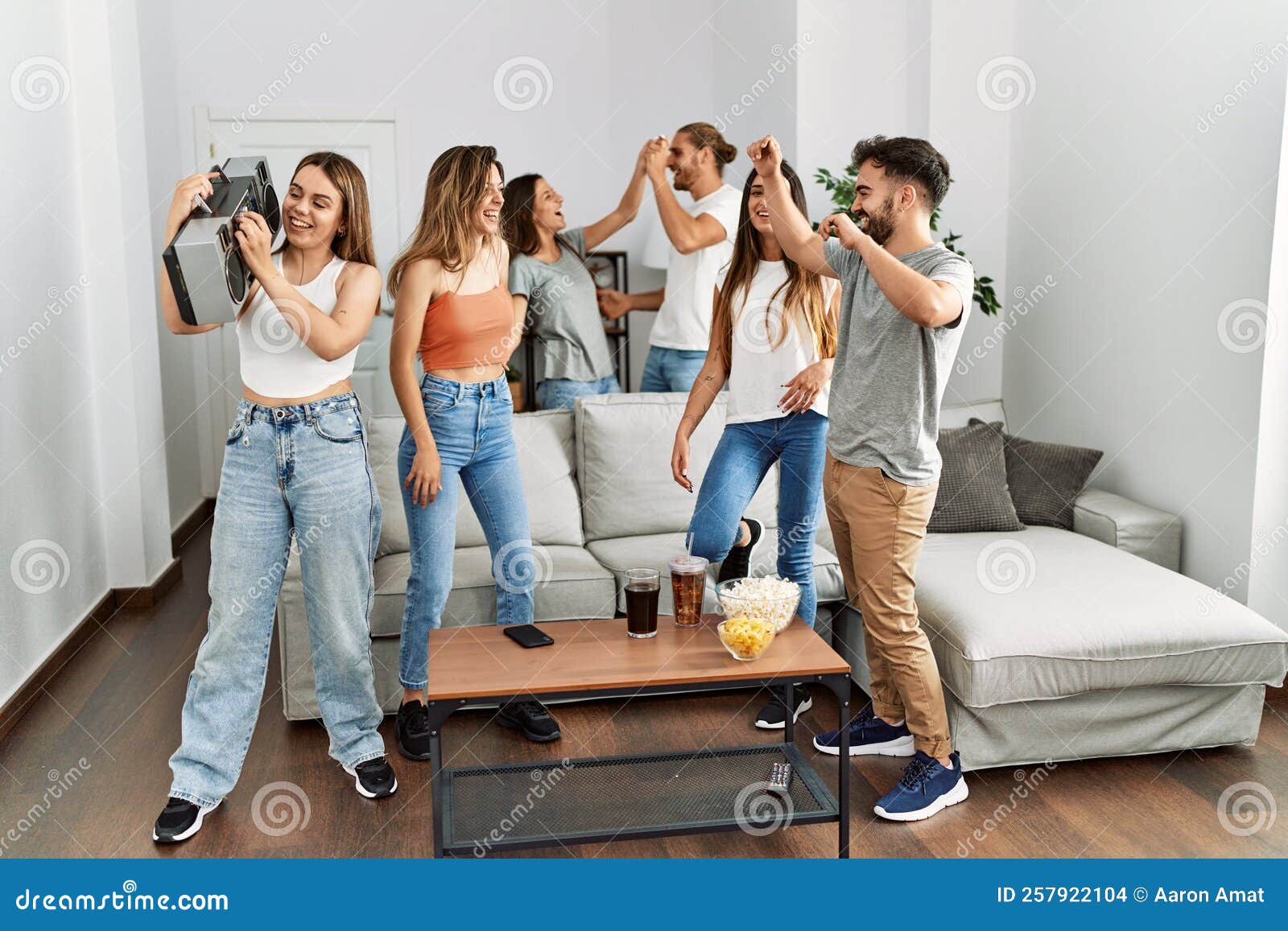 Group of Young Friends Smiling Happy and Dancing at Home Stock Photo