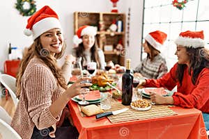 Group Of Young Hispanic Women Having Christmas Dinner Sitting On The Group Of Young Hispanic Women Having Christmas Dinner Sitting On The