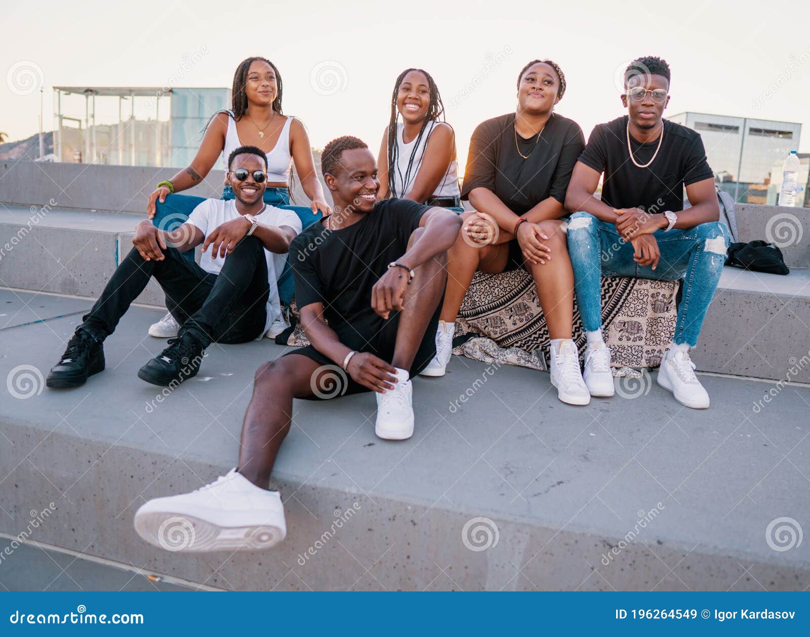 group of young modern african black friends happily sitting together