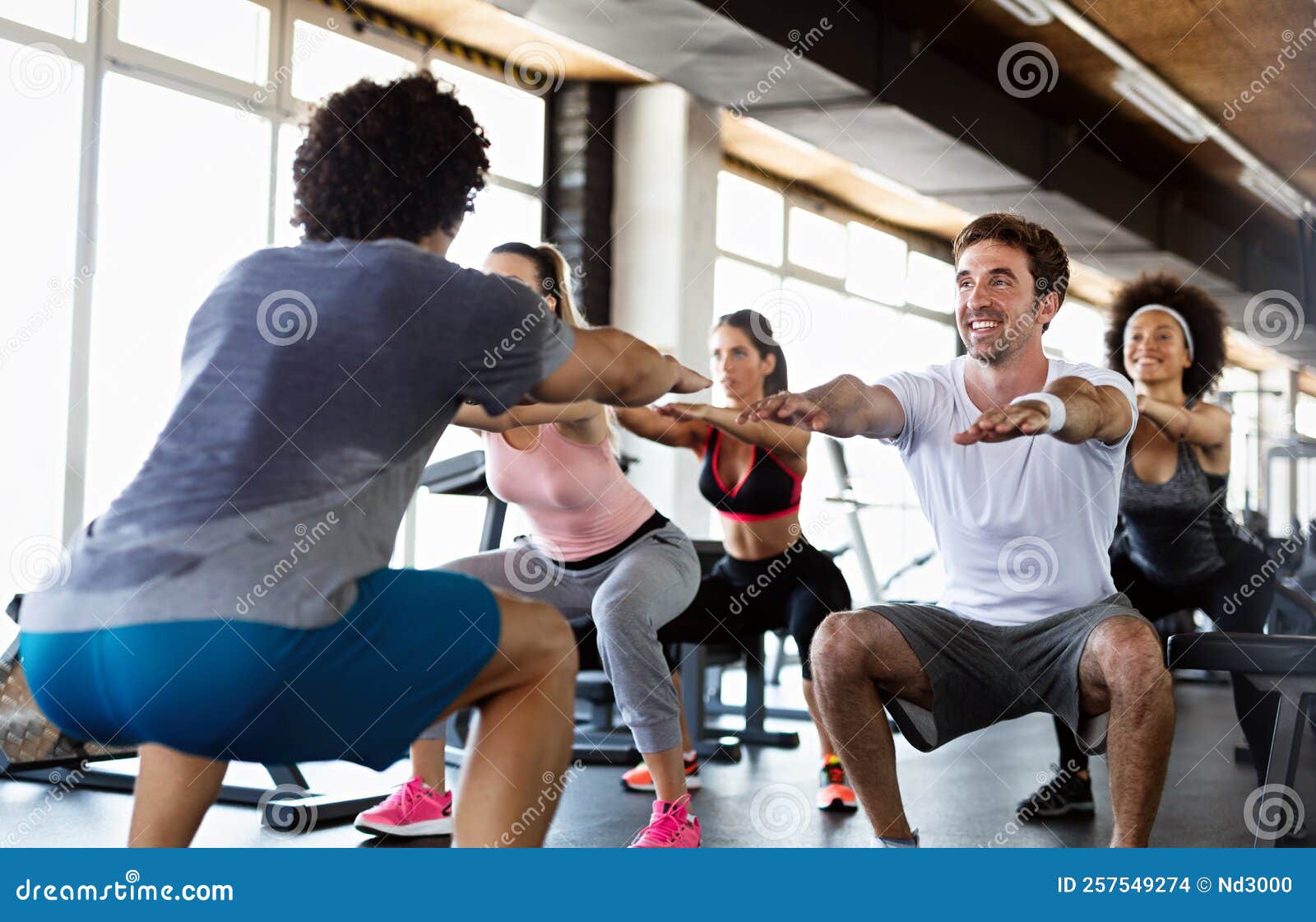 Fitness, sport, training, gym and lifestyle concept. Group of smiling people  exercising in the gym Stock Photo by nd3000