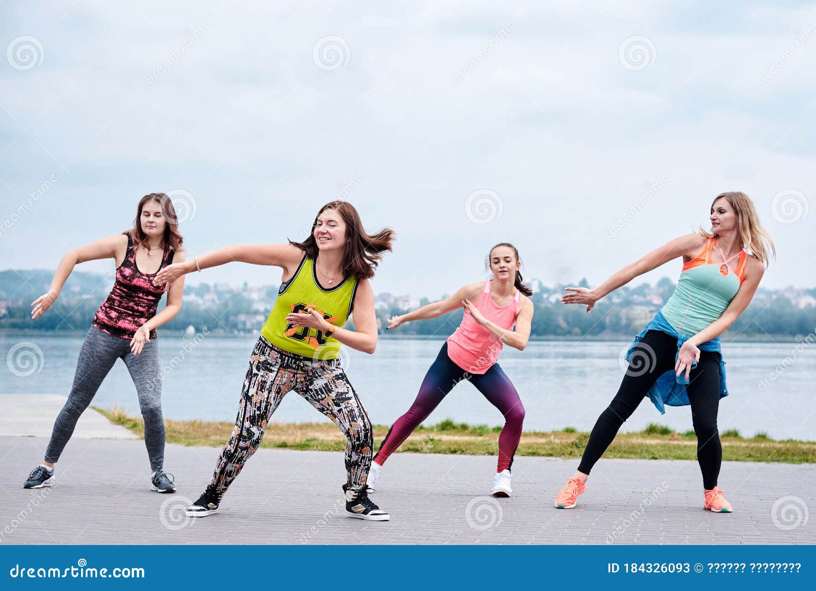 A Group of Young Women, Wearing Colorful Sports Outfits, Doing Zumba  Exercises Outside by City Lake. Dancing Training To Loose Stock Image -  Image of athletic, loss: 184326093