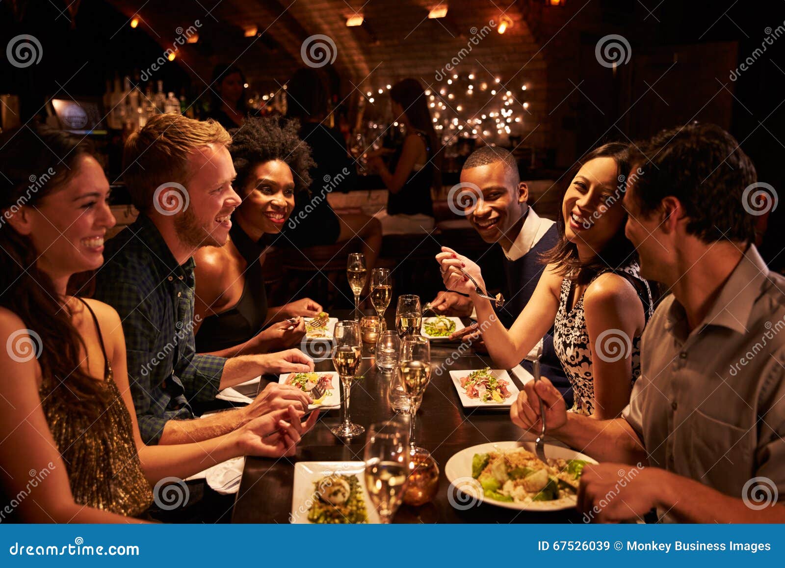 Groupe D'amis Appréciant Le Repas Dans Le Restaurant Image stock