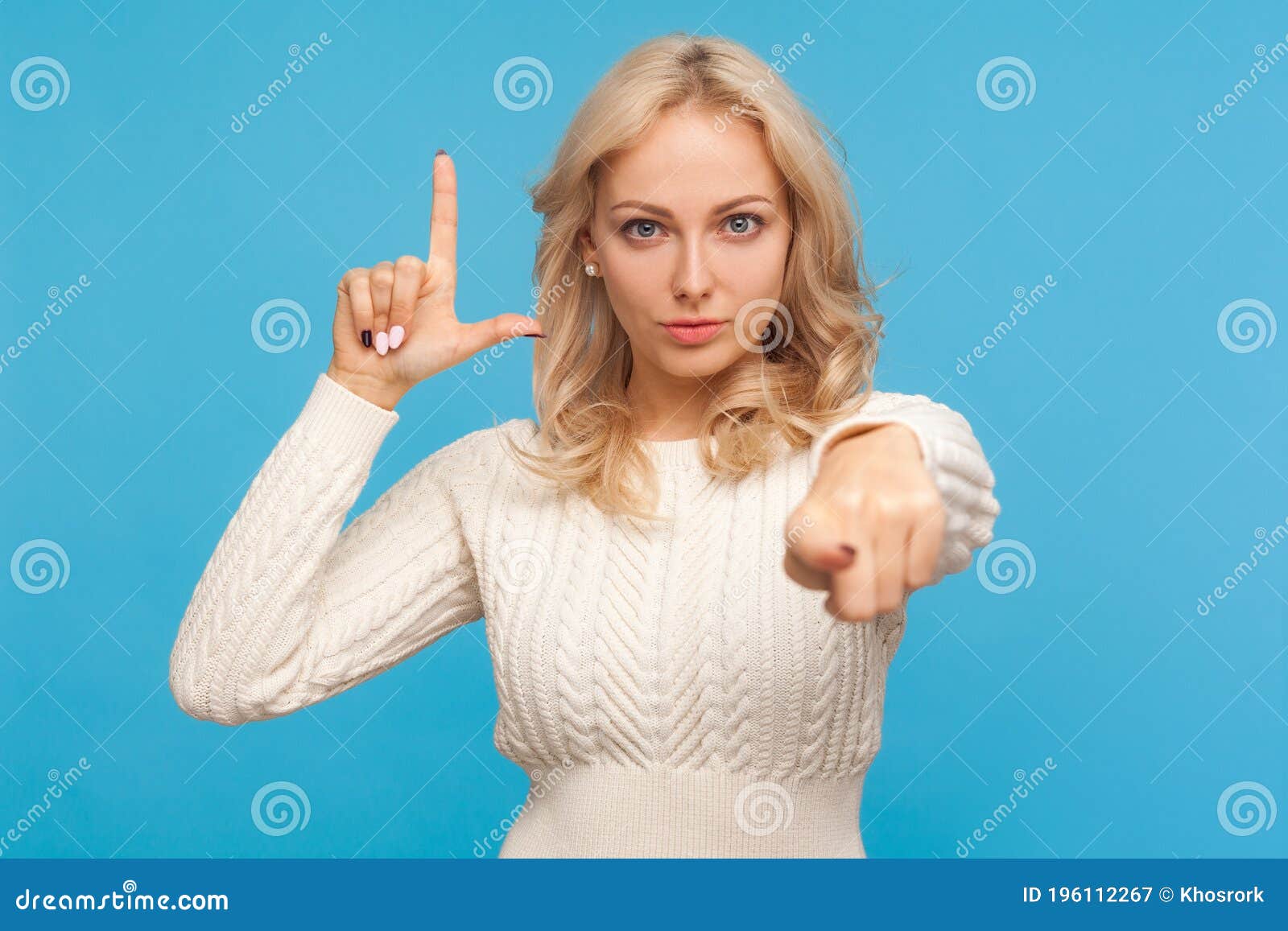 grumpy disrespectful woman with blond hair showing loser gesture and pointing finger at camera, blaming and mocking