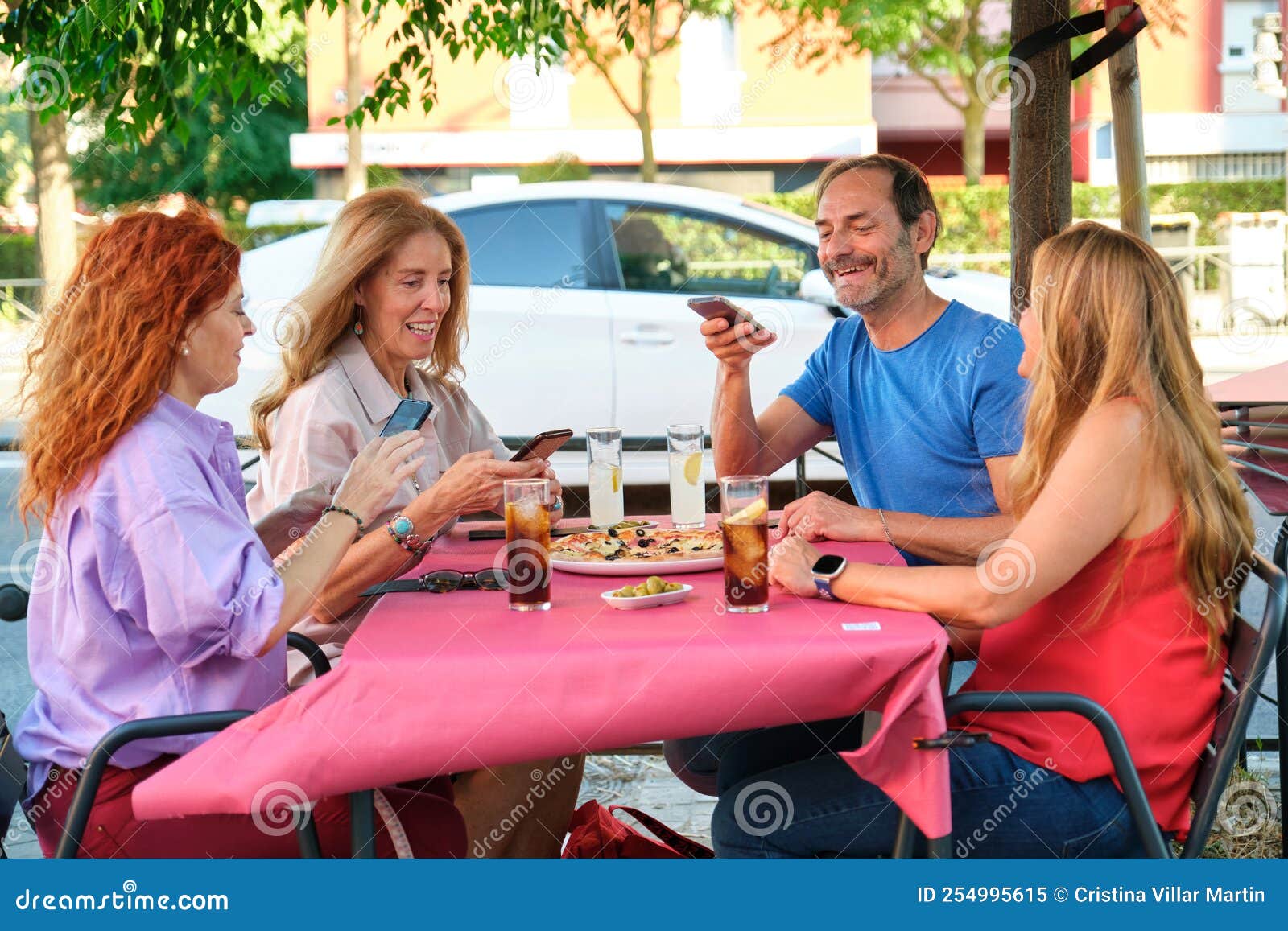 Garçonete bonita servindo grupo de amigas com comida no restaurante