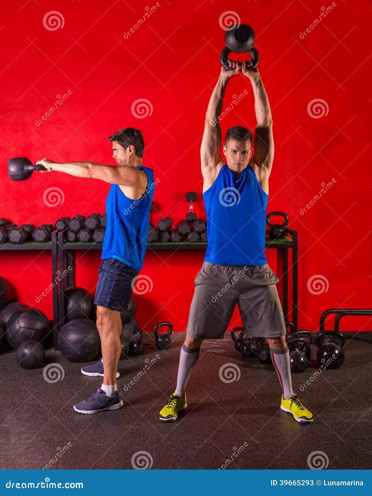 Grupo de entrenamiento del entrenamiento del oscilación de Kettlebell en el gimnasio con la pared roja