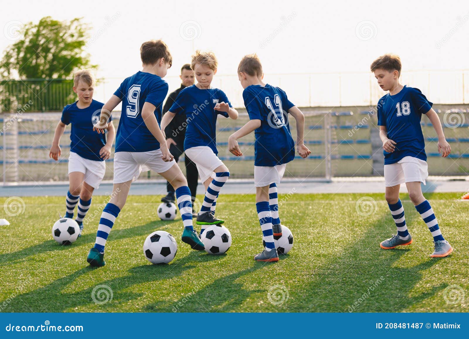 Grupo De Niños Jugando Fútbol En Sesión De Entrenamiento. Niños En Un Club  De Fútbol Con Camisetas Azules Y Kits De Fútbol Imagen de archivo - Imagen  de grupo, menor: 208481487