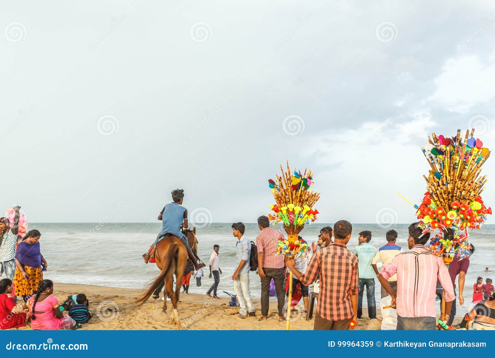 Gruppe von Personen trat am Jachthafenstrand zusammen und hatte Spaß in den Meereswogen mit schönen Wolken, Chennai, Indien am 19. Gruppe von Personen trat am Jachthafenstrand zusammen und hatte Spaß in den Meereswogen mit schönen Wolken im Himmel, die gesehenen Verkäufer, Esswaren durch Küste zu verkaufen