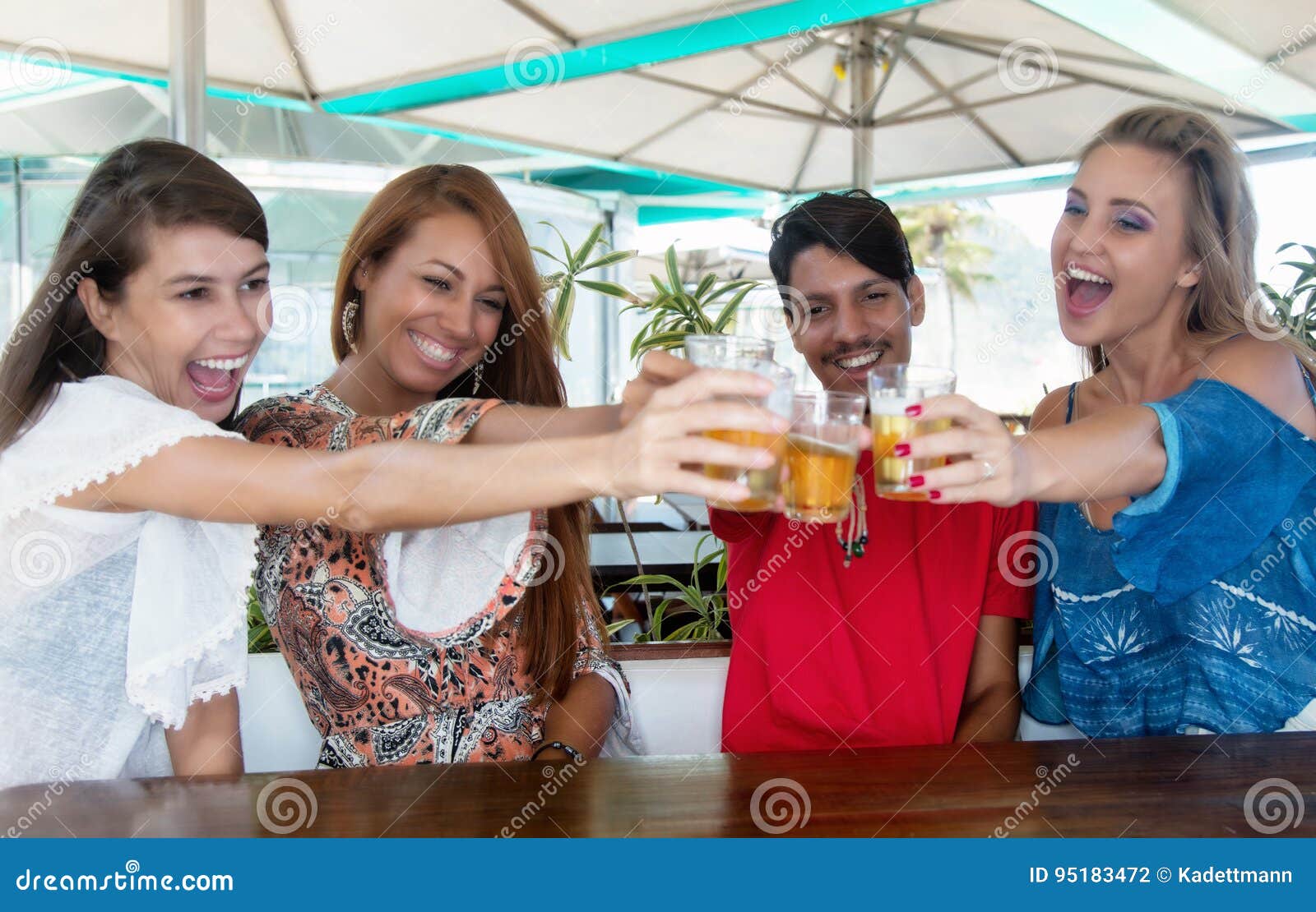 Gruppo di birra bevente della gente felice in una barra di estate