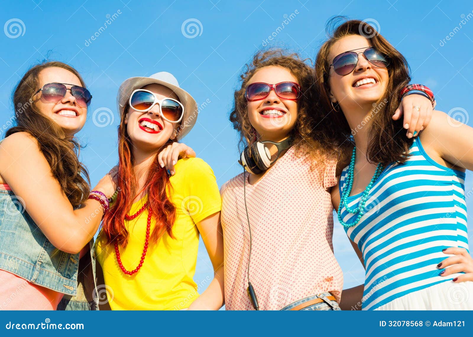 Gruppo di occhiali da sole d'uso e di cappello dei giovani. Gruppo di occhiali da sole d'uso e di cappelli dei giovani che abbracciano e che stanno in una fila, spendente tempo con gli amici
