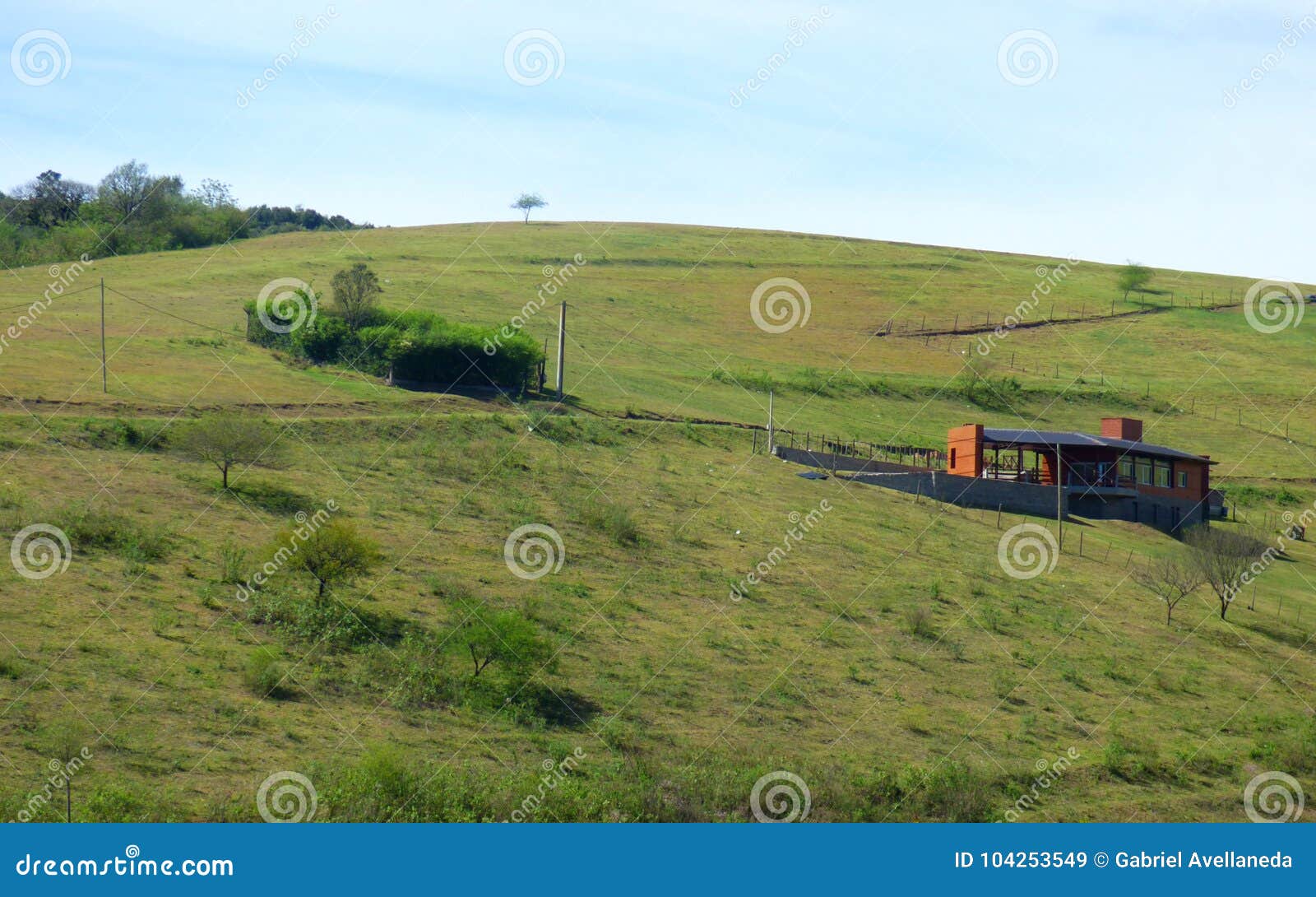 Grüne Hügel Hügel bedeckt durch Gras Es gibt ein lokalisiertes orange Haus mitten in dem Feld Landwirtschaftliche Lebensdauer