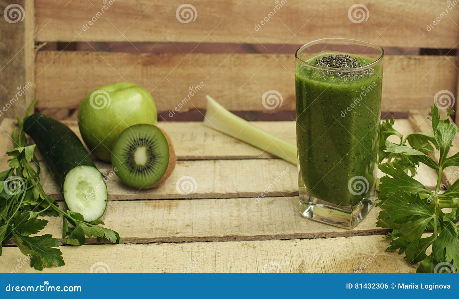 Grüner Detoxhintergrund mit Smoothie, Gemüse und Früchten. Horizontaler hölzerner Hintergrund mit grünem Detox Smoothie gemacht von der Gurke, Kiwi, Apfel, Sellerie, Petersilie, chia Mit Frischgemüse und Früchten Selektiver Fokus