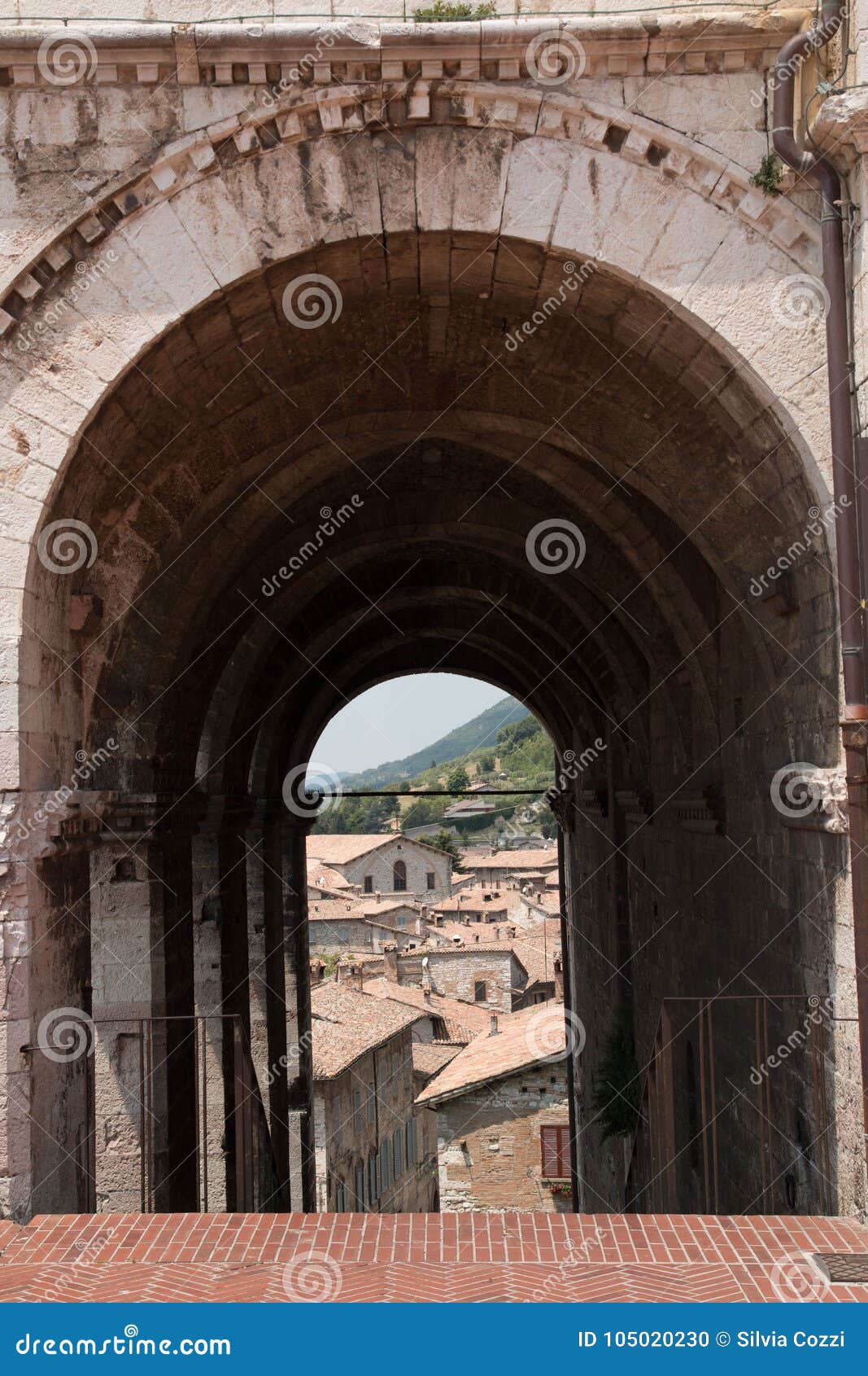 Gubbio, puerta medieval con la visión. Gubbio es un pueblo medieval situado en Italia central, en la región de Umbría Esta imagen muestra un detalle de su arquitectura antigua, una opinión medieval del wuth de la puerta sobre los edificios viejos