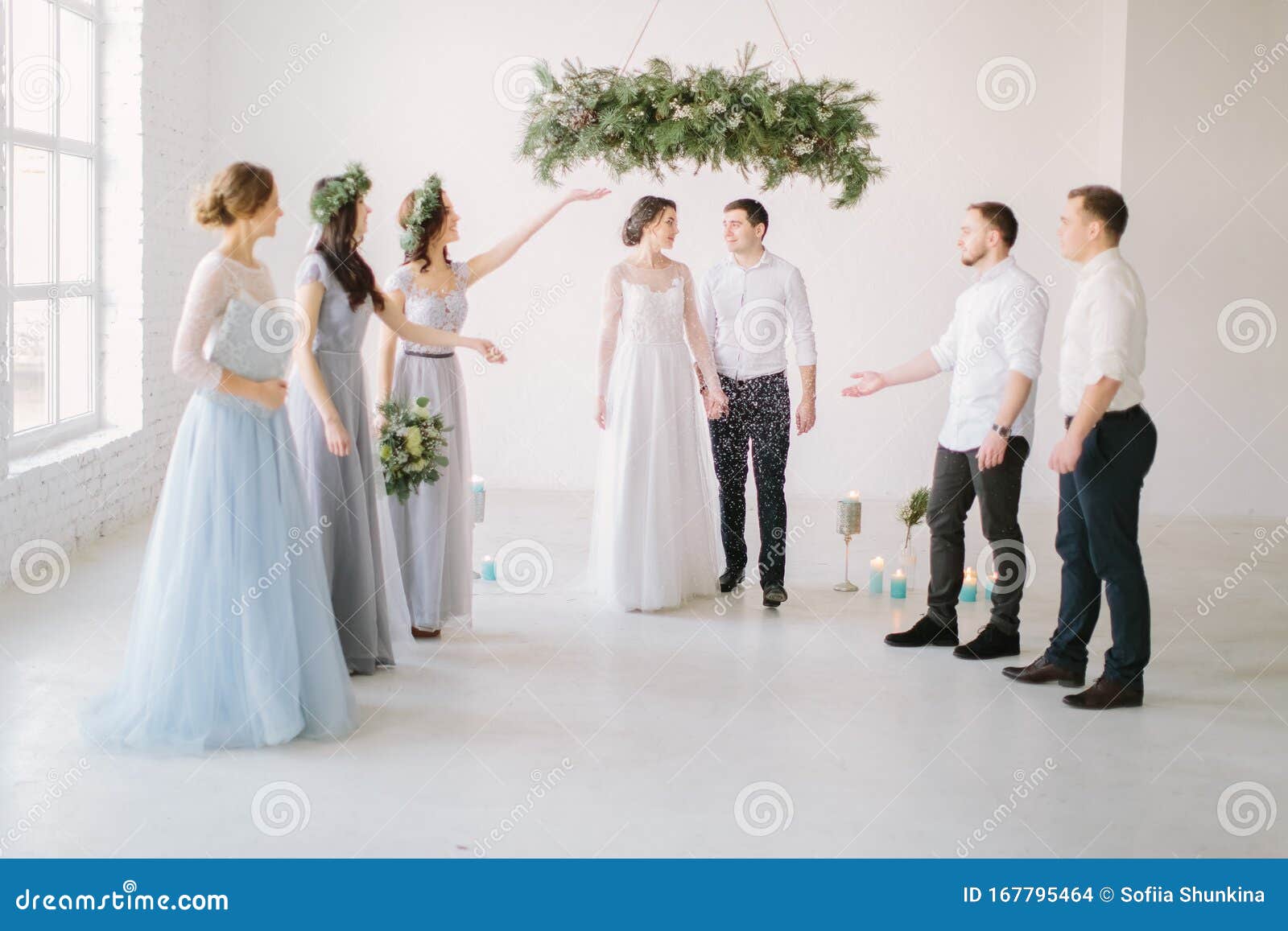 Guests Throwing Confetti Over Bride and Groom at Wedding Stock Photo