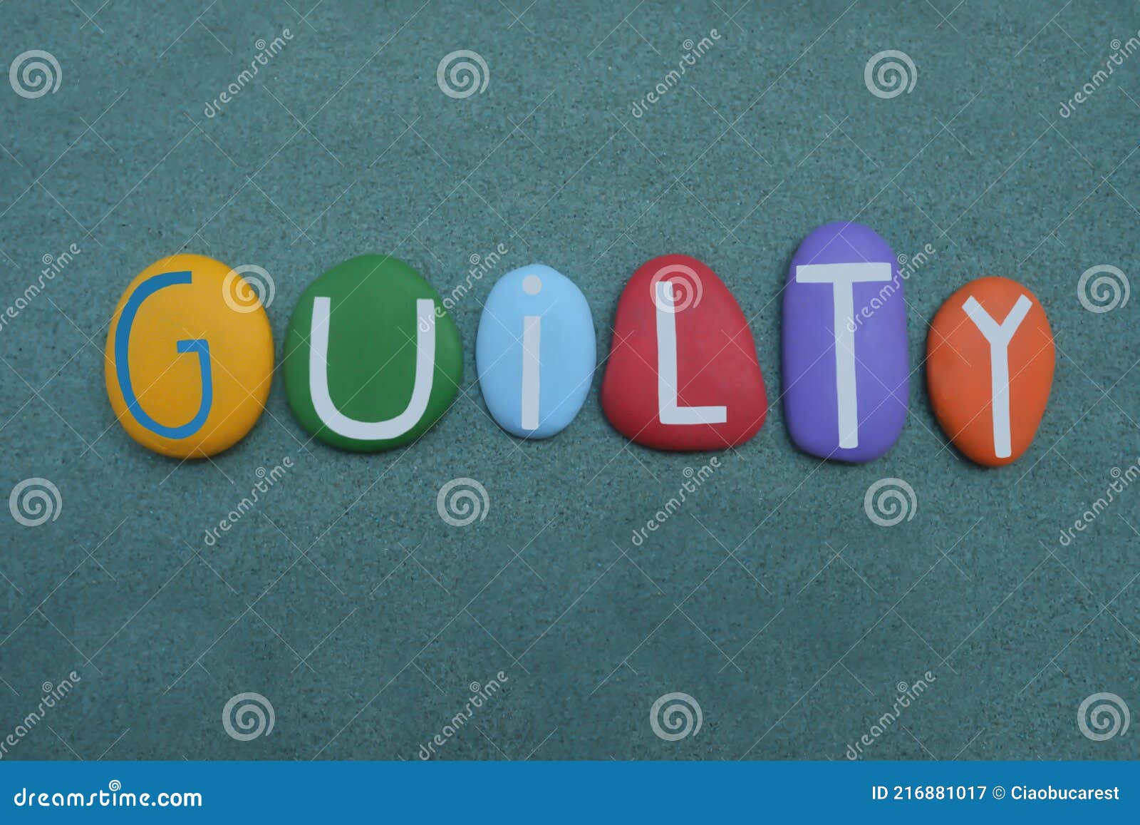 guilty word composed with multi colored stone letters over green sand