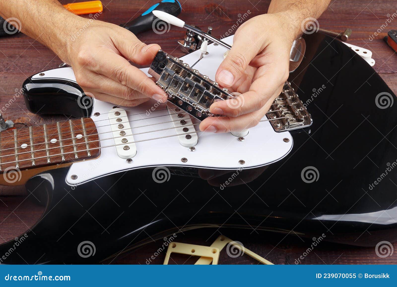 Guitar Master Repairs Tremolo Bridge from Electric Guitar Stock Image
