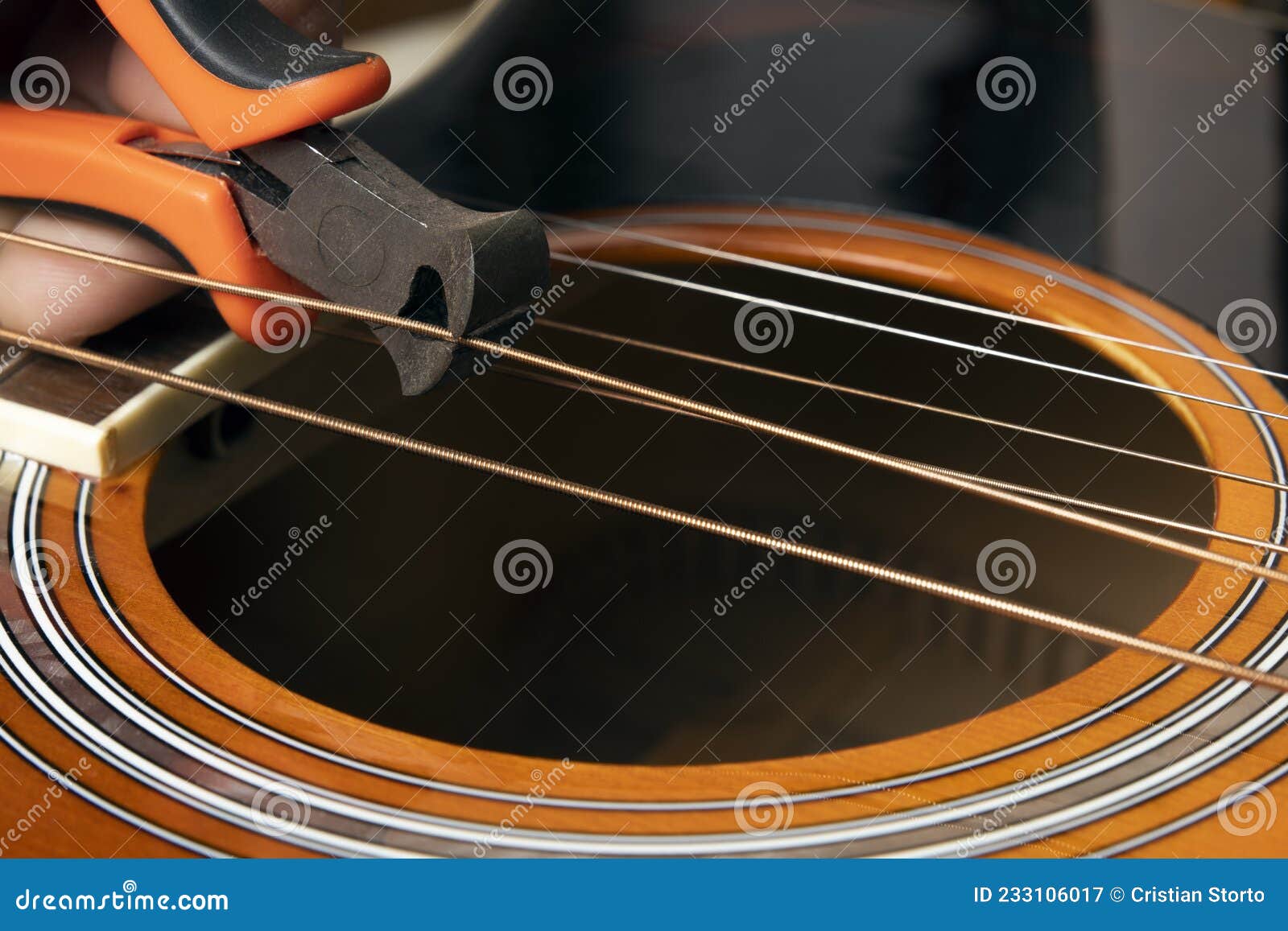 guitar restring: musician cut strings from an acoustic guitar