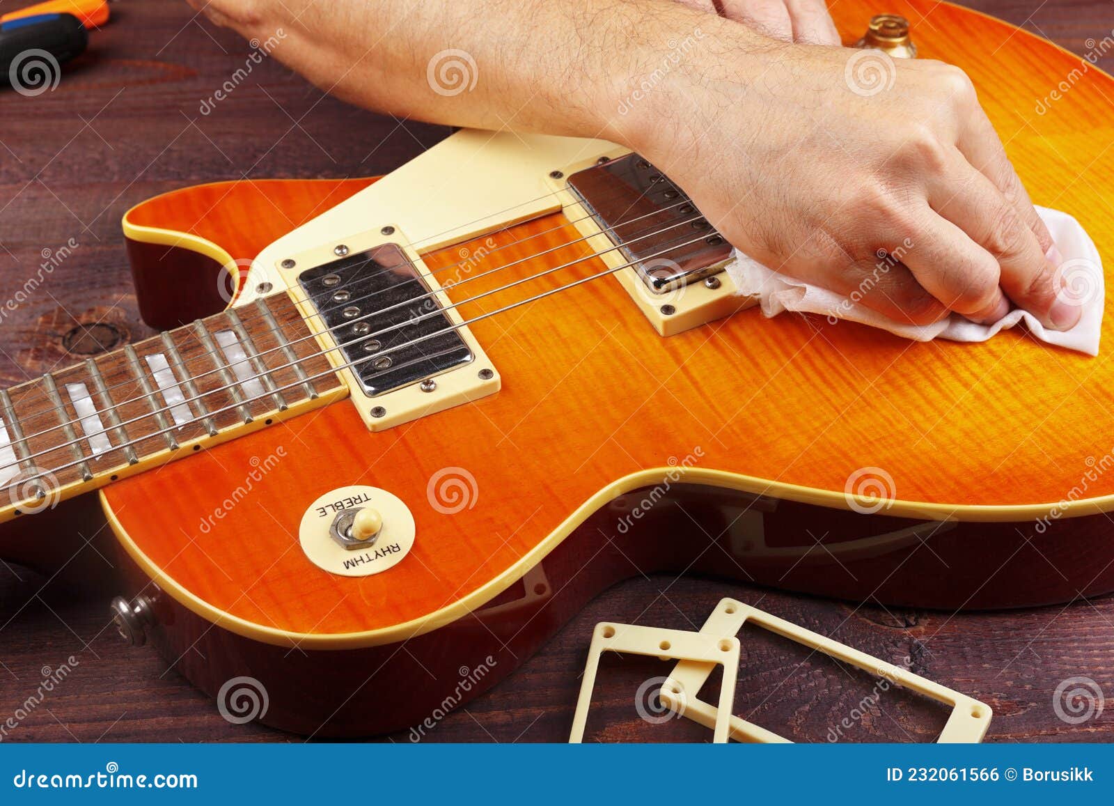 Guitar Technician Wipes Varnished Surface of Electric Guitar with Rag