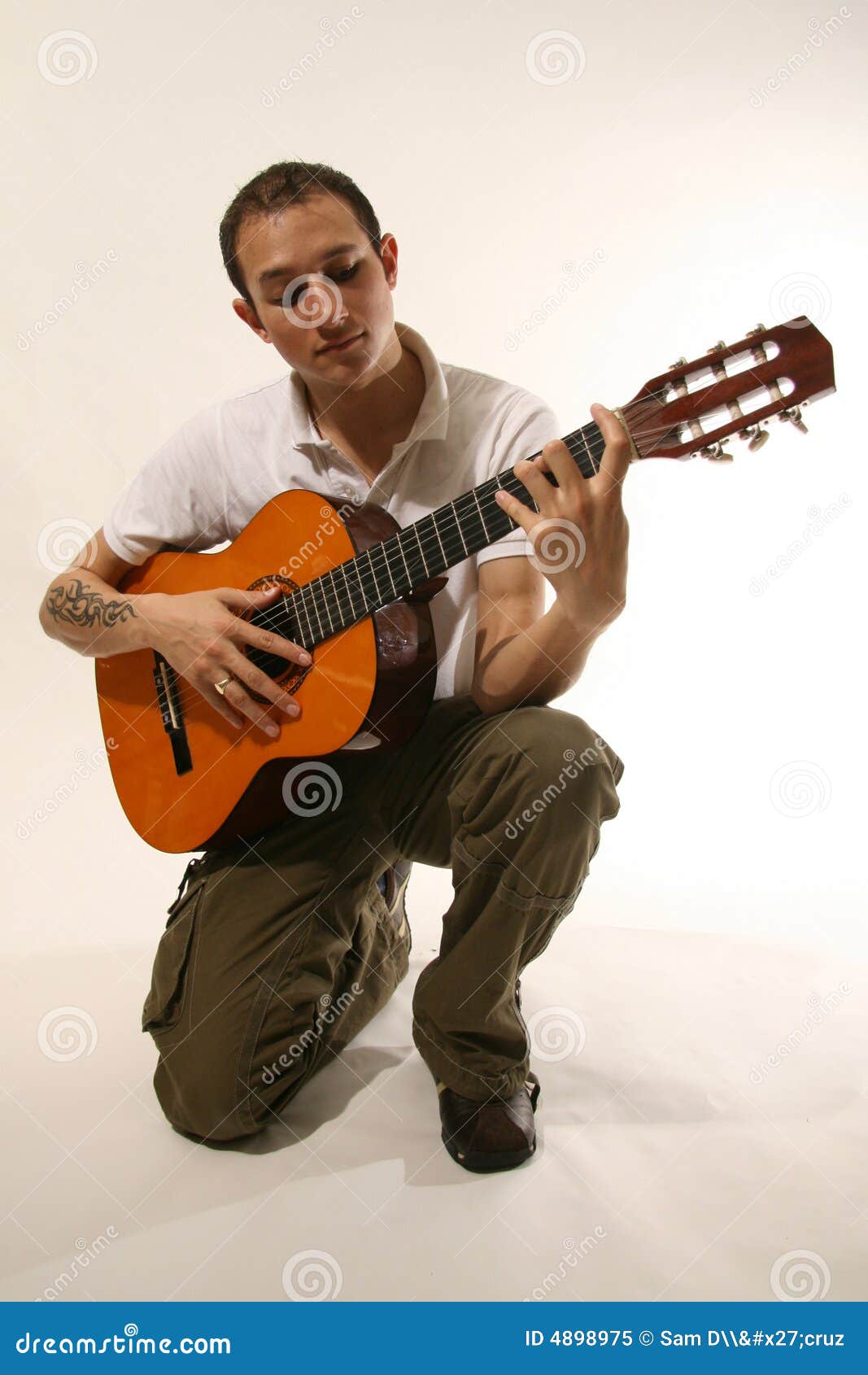 Guitarrista en estudio. Guitarrista - hombre joven apuesto en la configuración del estudio