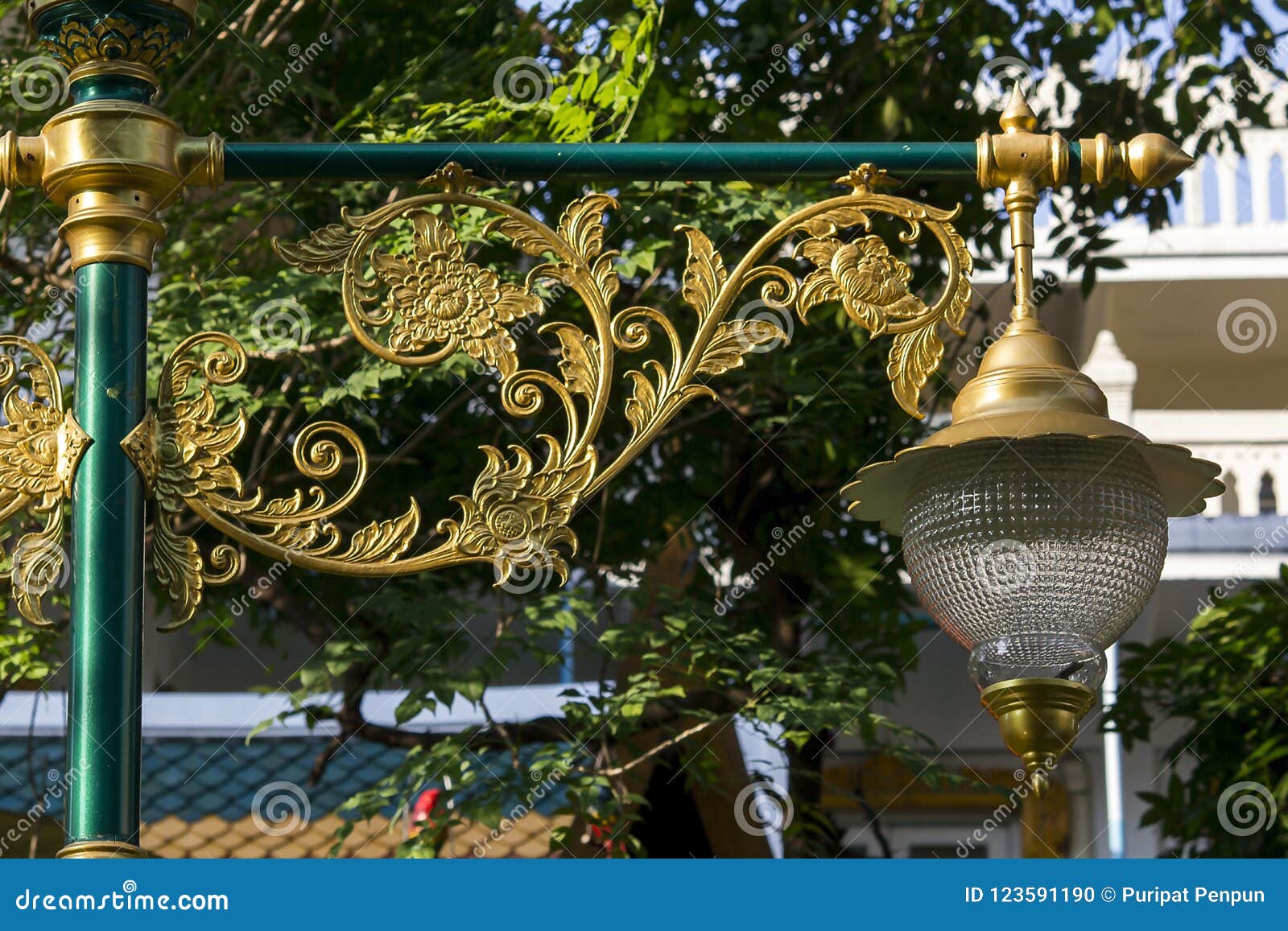 Guld- lampa med den thailändska modellen. Den Glass lampan dekoreras med guld- motiv som är unika i Thailand