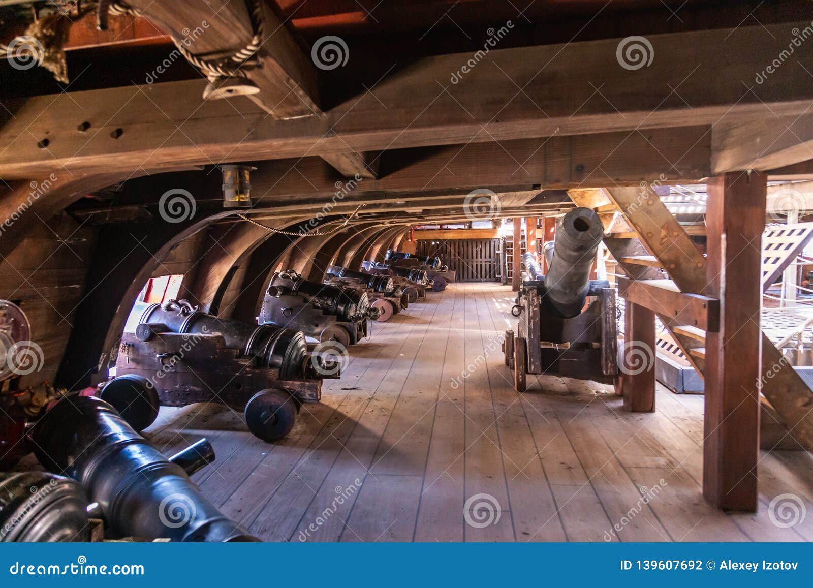 on the gun deck of an old pirate ship moored in the port