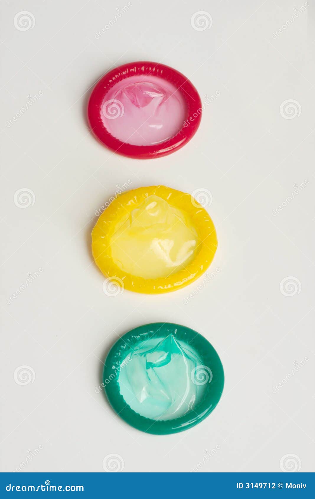 Gusto colocado tres preservativos. Tres preservativos. Amarillo y verde rojos colocados como un semáforo. Fondo blanco.