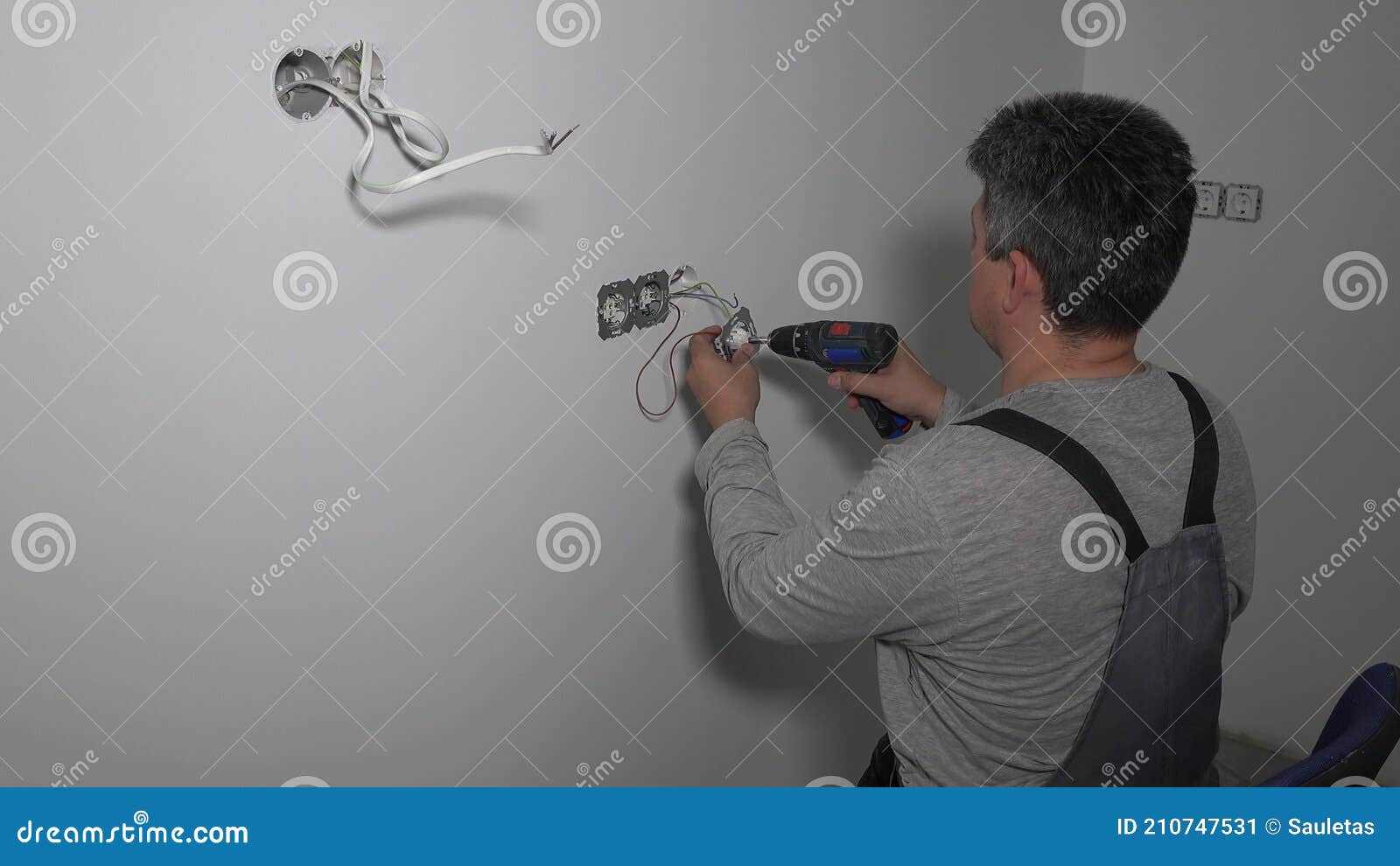 Guy with Cordless Drill Electrical Outlet. Do it Yourself Stock Video