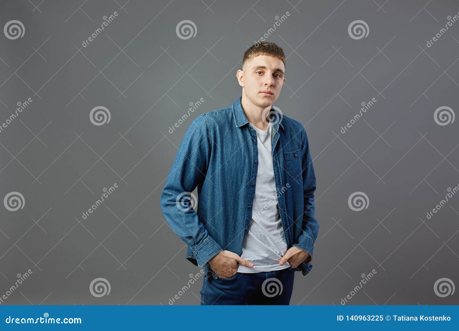 Guy Dressed in a White T-shirt, Jeans and Jeans Shirt Holds His Hands ...