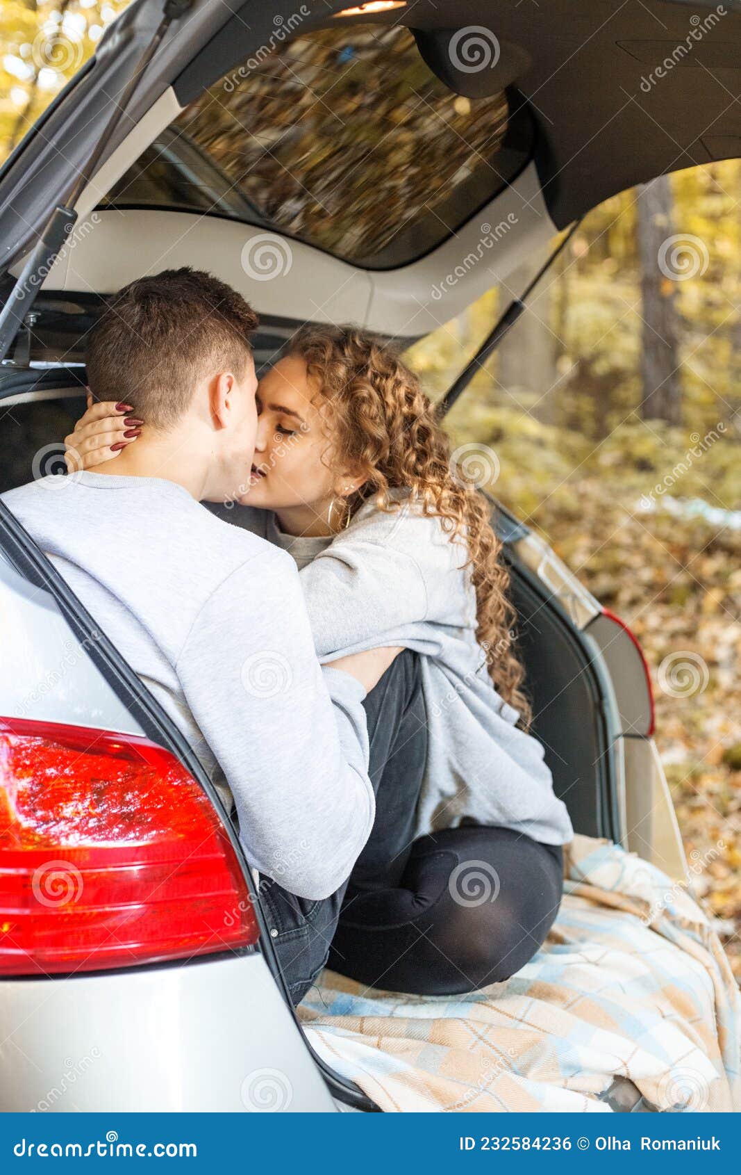 The Guy and the Girl are Kissing in the Trunk of the Car. Autumn Forest