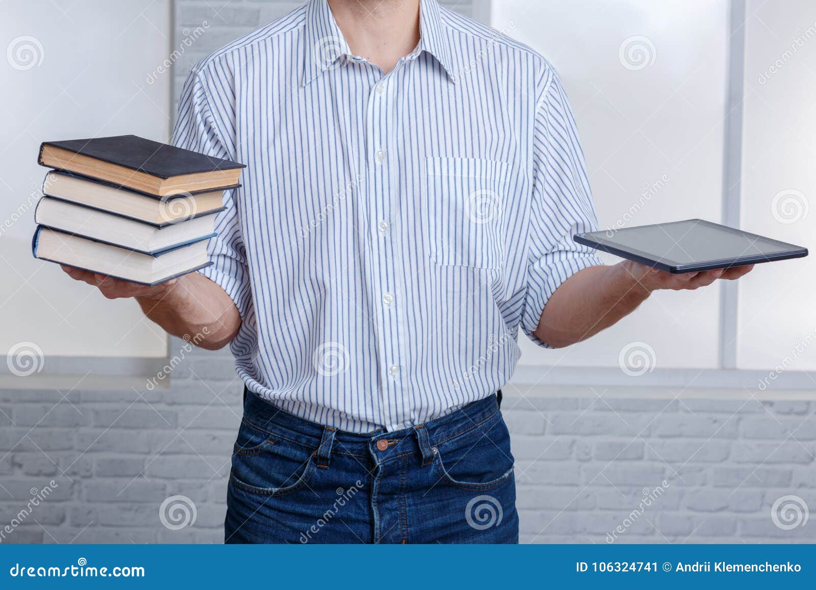 A Guy in One Hand Holding a Stack of Books and a Tablet. Stock Image