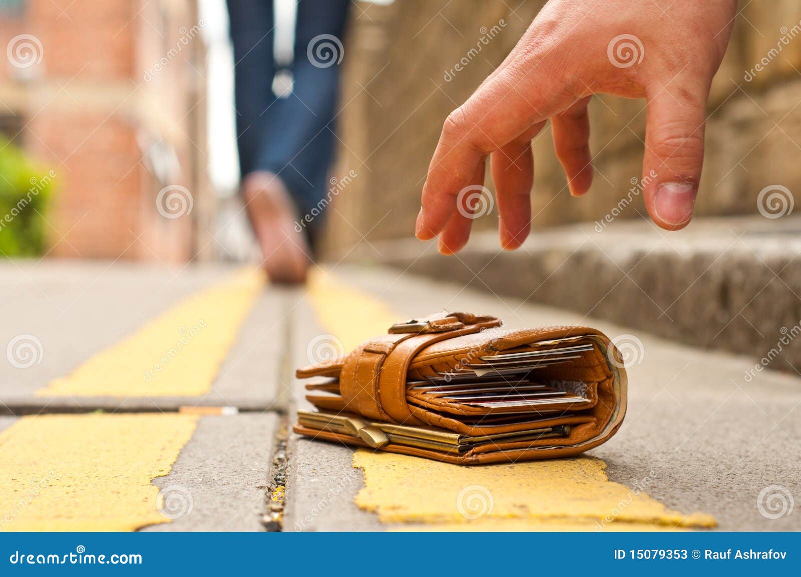 guy picking up a lost a lost purse/wallet