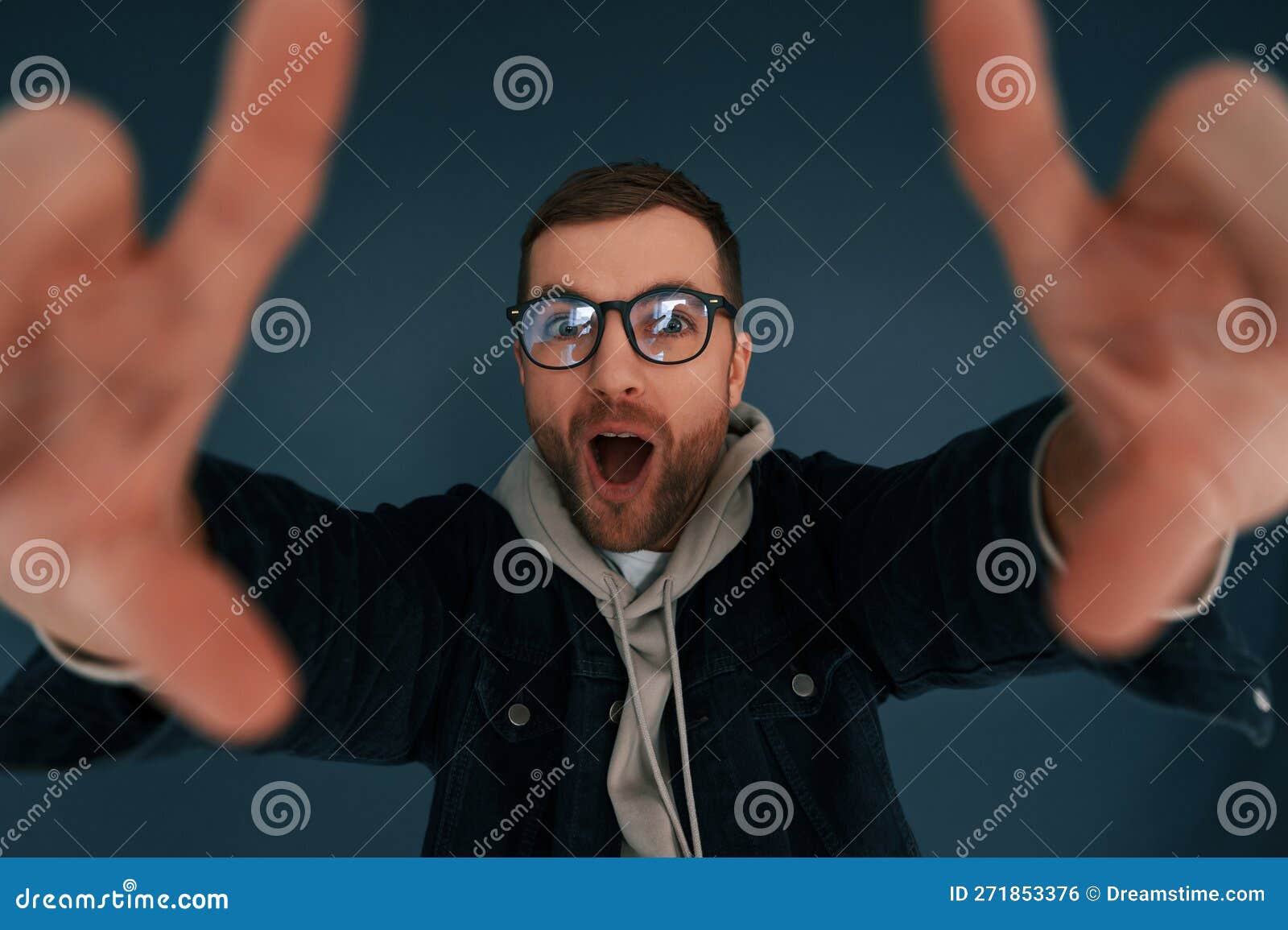 Guy is Pretending that he S Doing Photoshoot by Using Hands Gestures