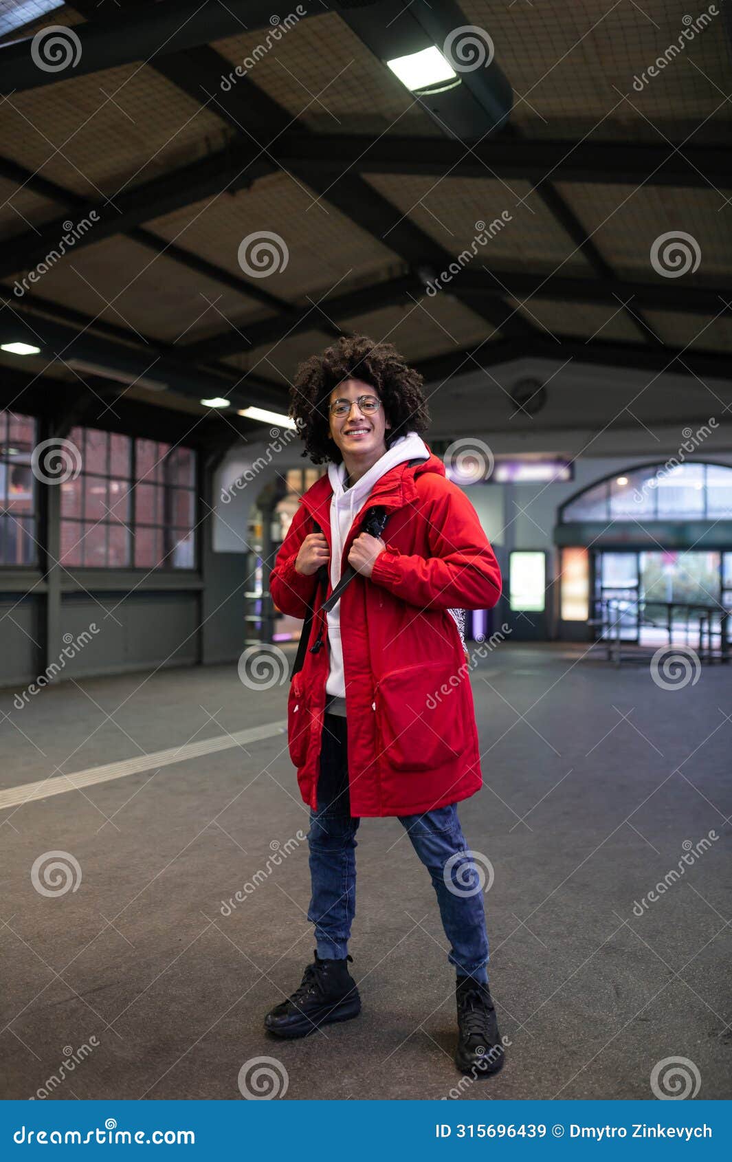 Guy in Red Jacket Waiting for the Train on a Railway Platform Stock