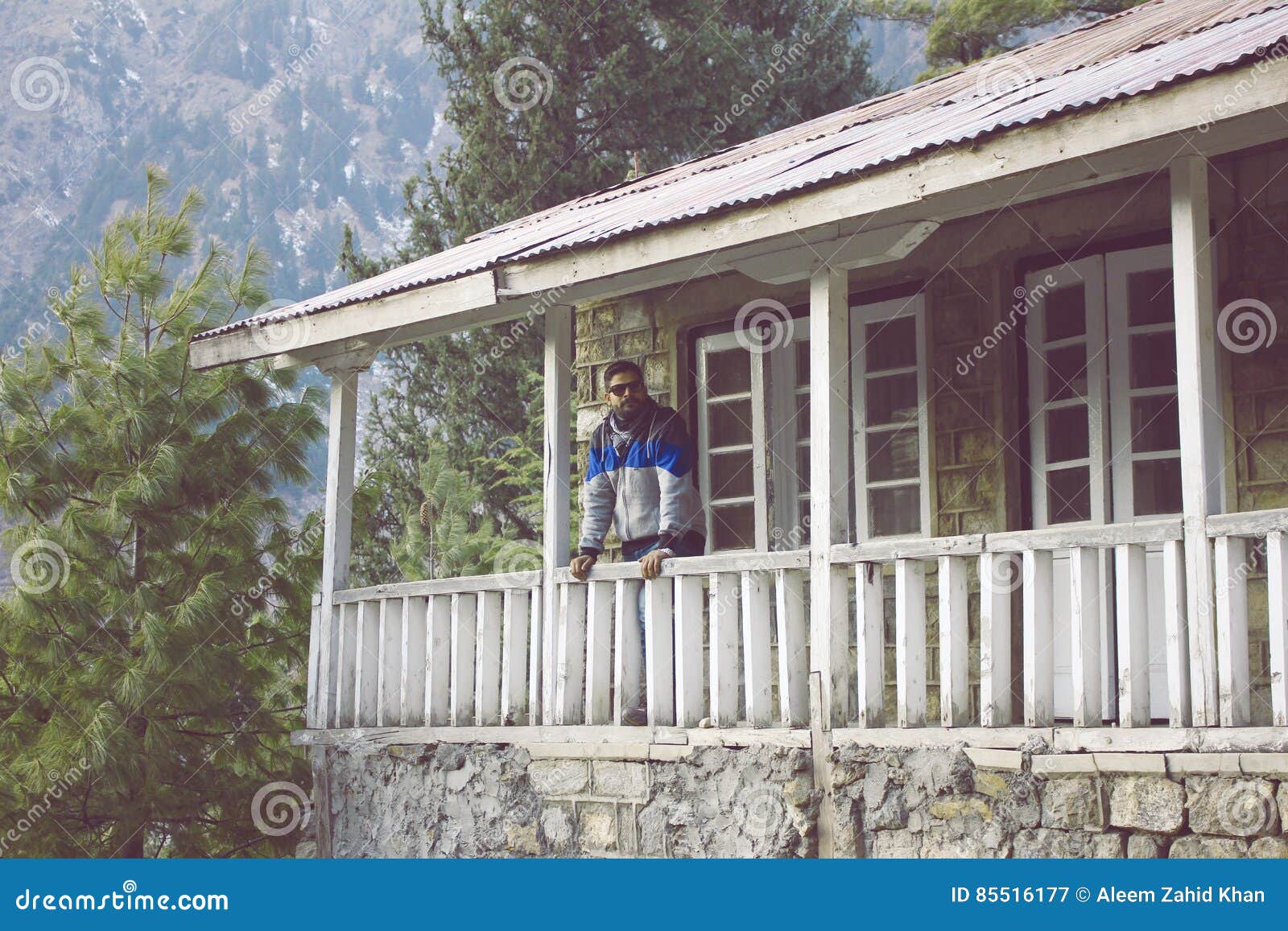 Guy Standing On Terrace Of A Cottage In Mountain Stock Image