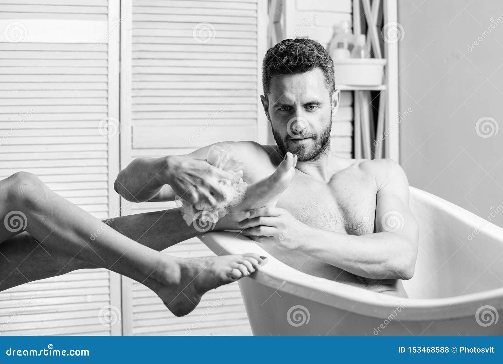 Guy Wash Female Legs with Foam Sponge. Macho Enjoying Bath photo