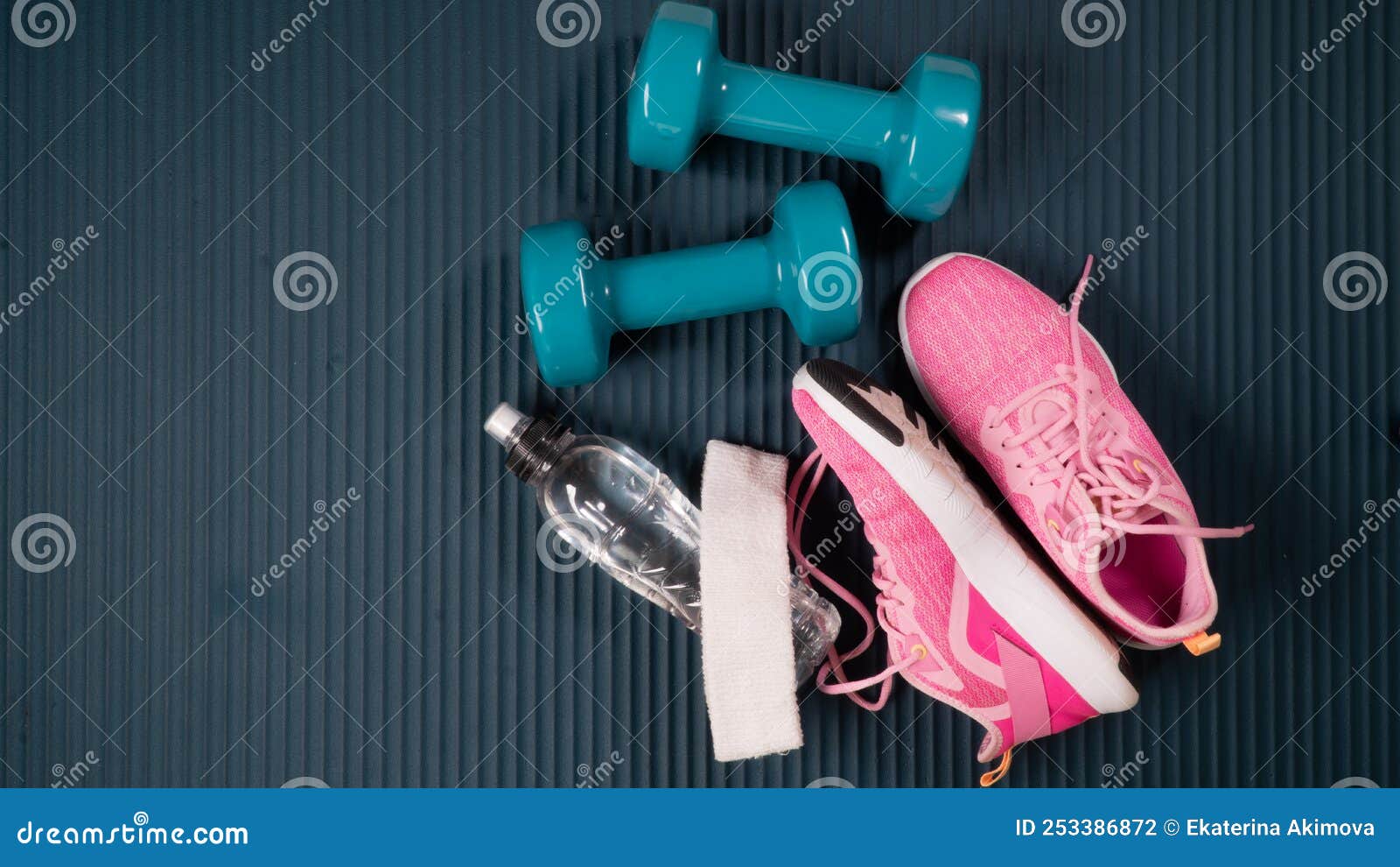 gym workout kit - dumbbells with sneakers, bottle of water, towel and buff