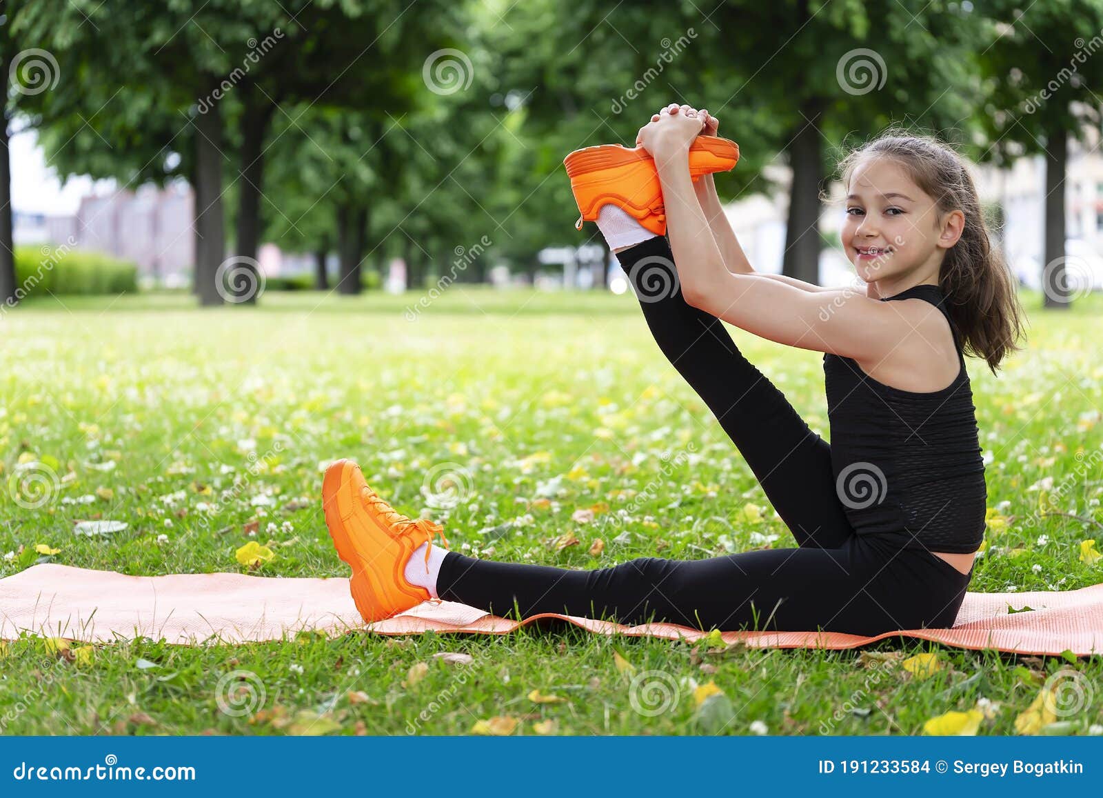 Gymnast Schoolgirl Warming Up in a Grass Park before Performing Complex ...