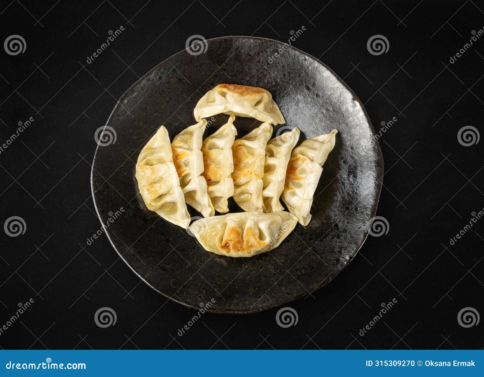 gyoza chinese dumplings top view, vegetable jiaozi, chicken momo pile, asian gyoza portion on black
