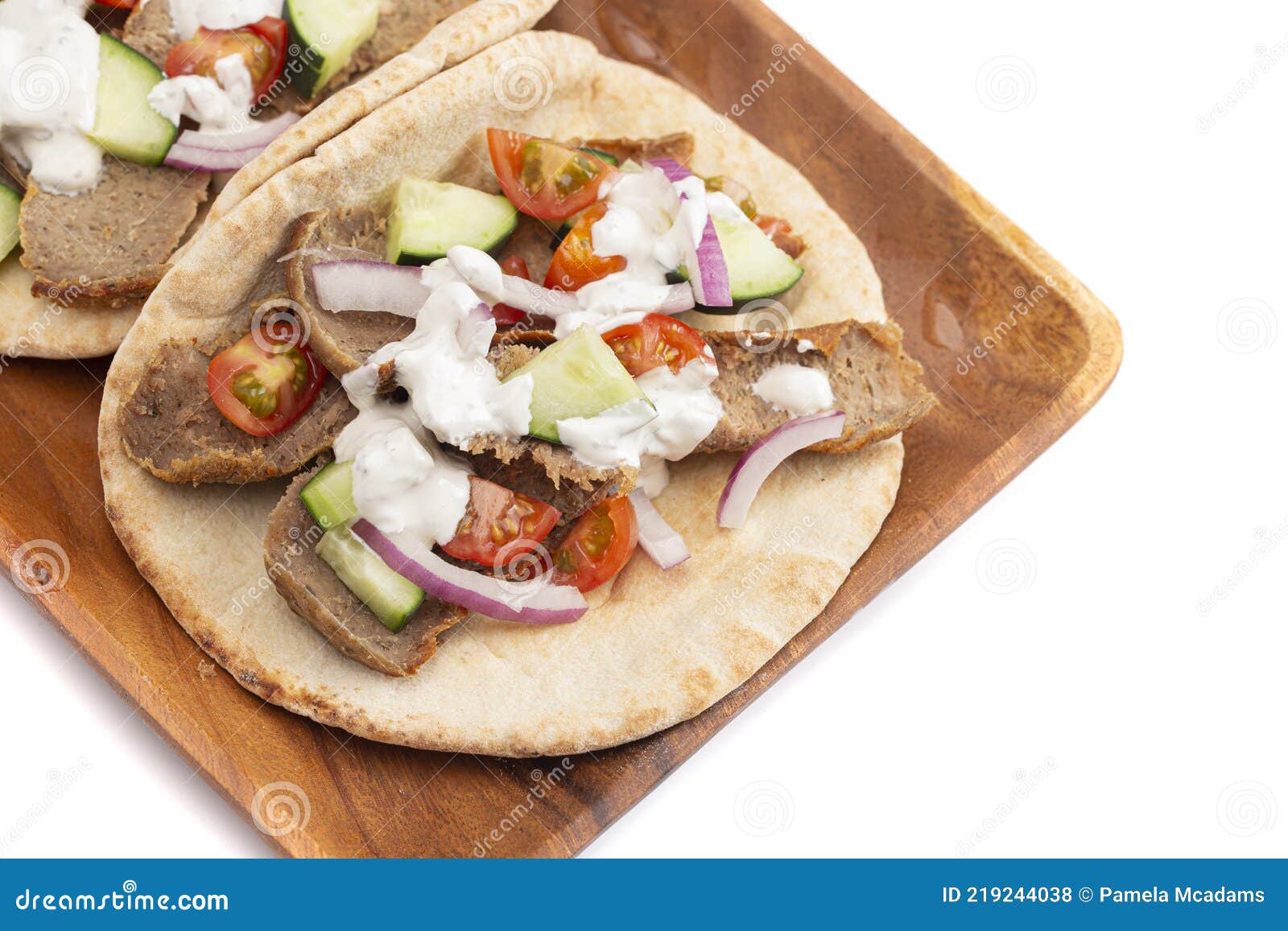A Gyro with Vegetables and Garlic White Sauce on a White Background